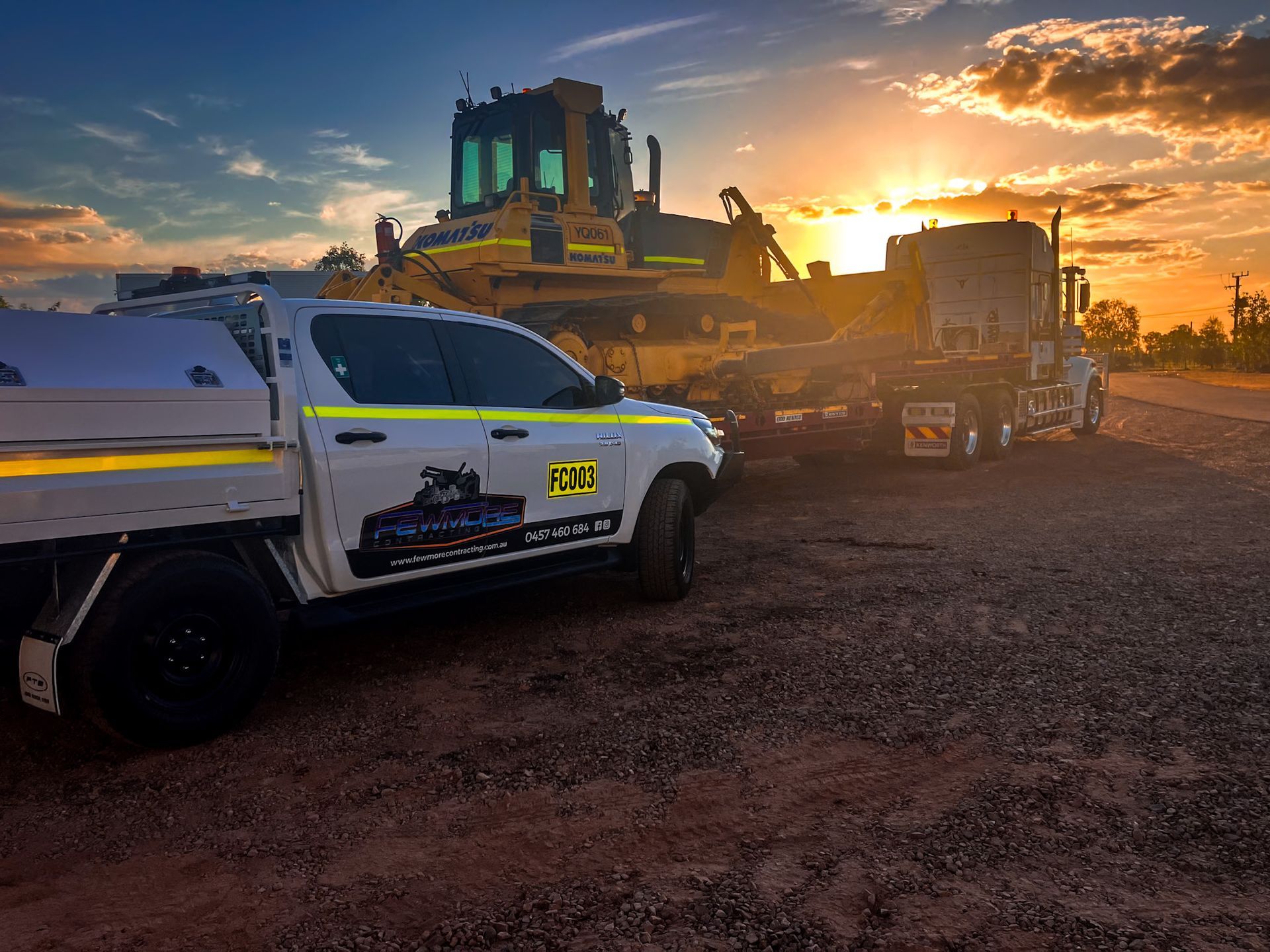 A Truck is Parked Next to a Bulldozer at Sunset — Fewmore Contracting in Yarrawonga, NT