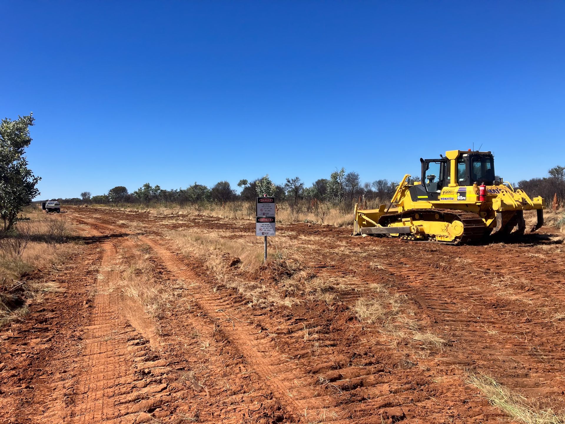 A Yellow Bulldozer is Sitting in the Middle of a Dirt Field — Fewmore Contracting in Humpty Doo, NT