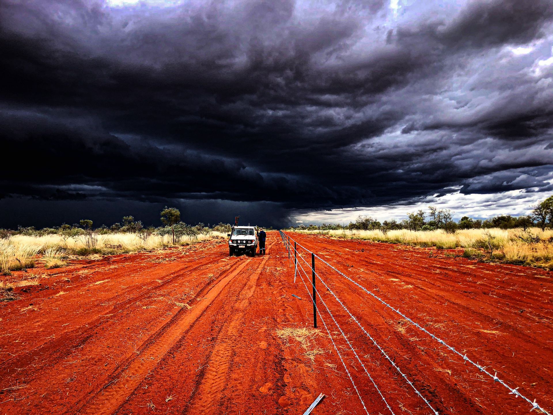 A Truck is Driving Down a Dirt Road Under a Cloudy Sky — Fewmore Contracting in Palmerston, NT