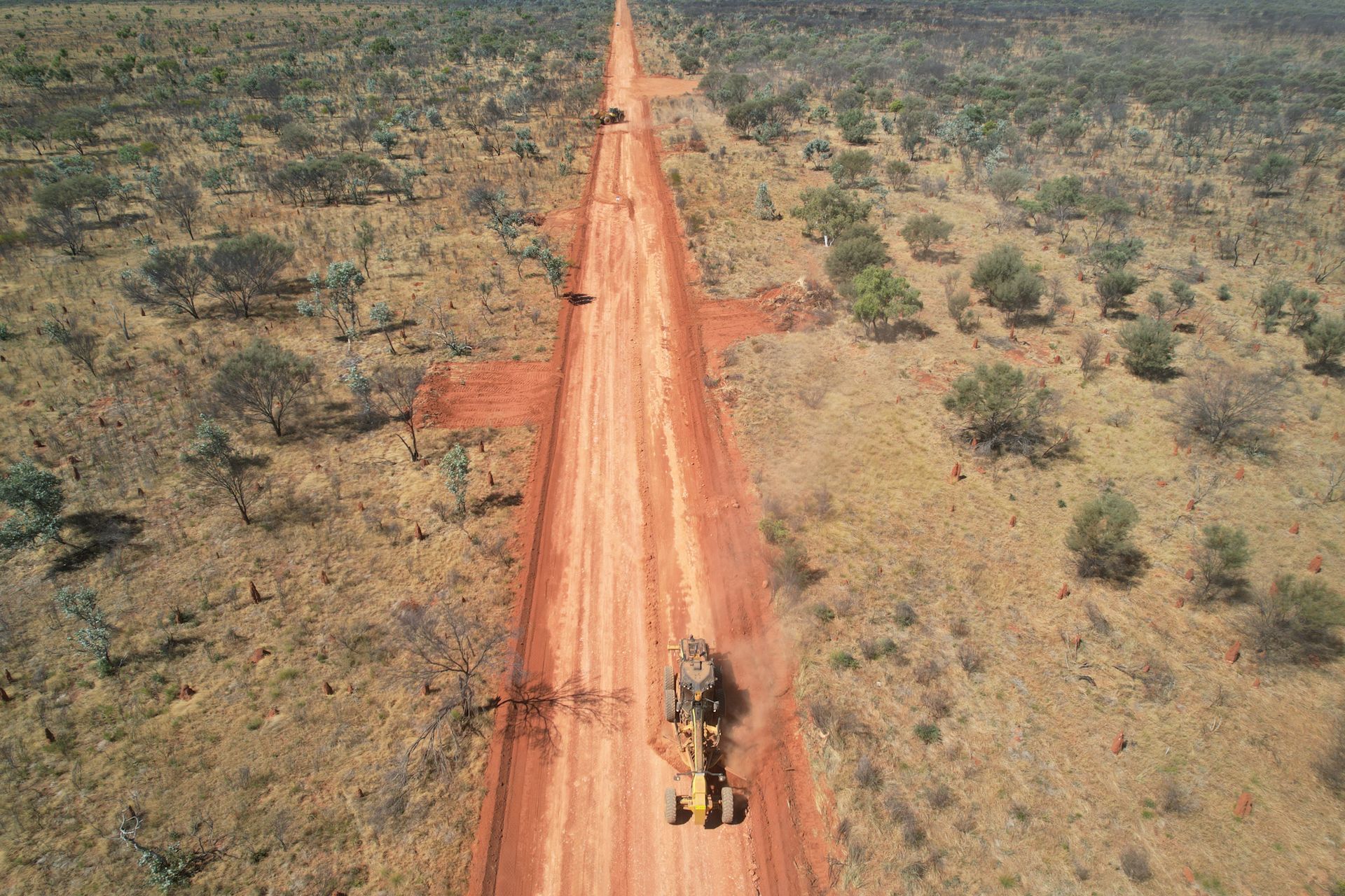 An Aerial View of a Bulldozer Driving Down a Dirt Road in the Desert — Fewmore Contracting in Yarrawonga, NT