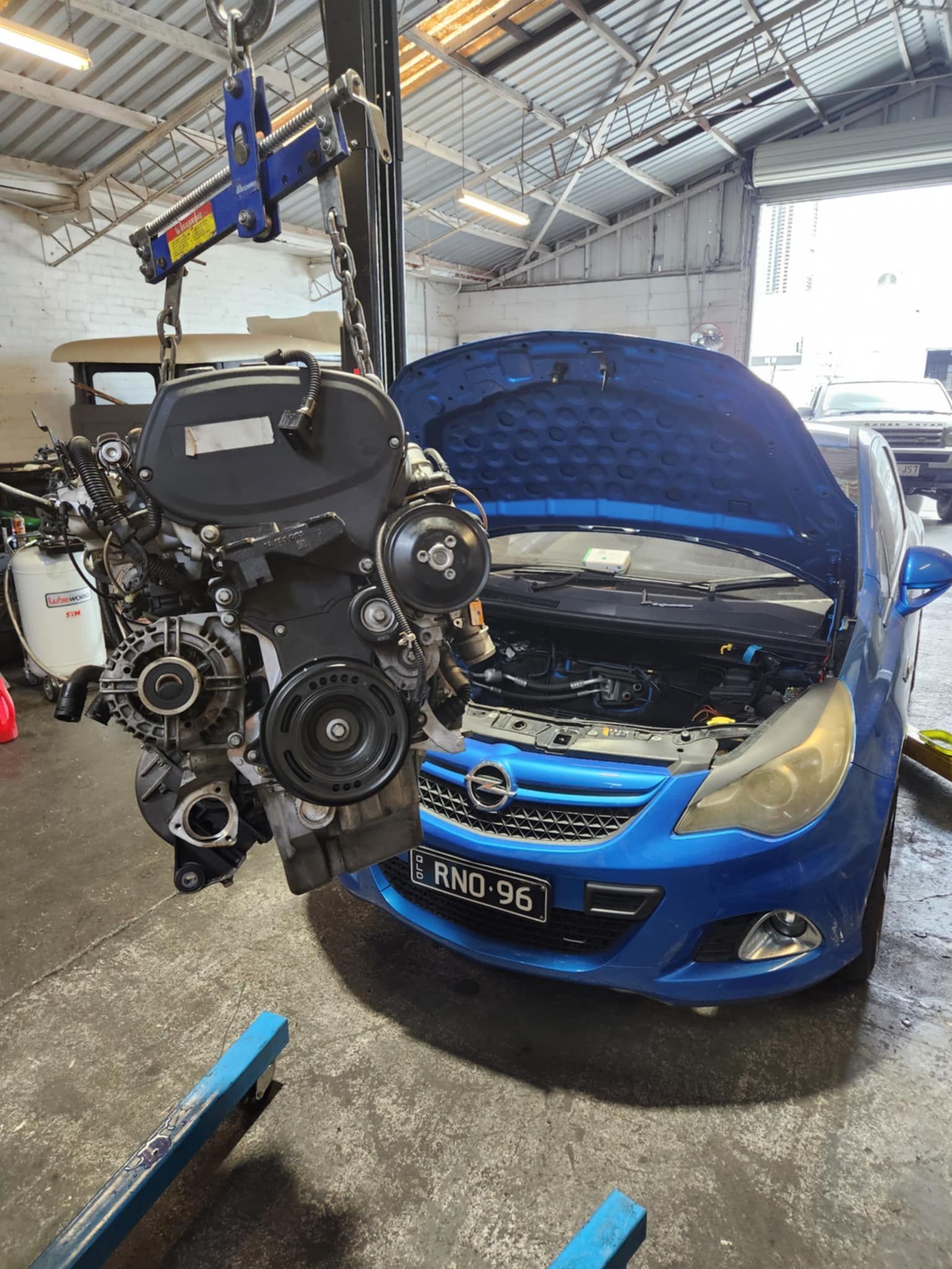 Engine on a Lift In Front of Blue Car — Sebring All Mechanical Repairs In Mermaid Beach, QLD