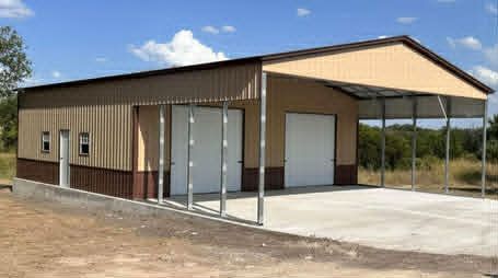 Tan metal building with a covered concrete entrance and large garage door under a blue sky