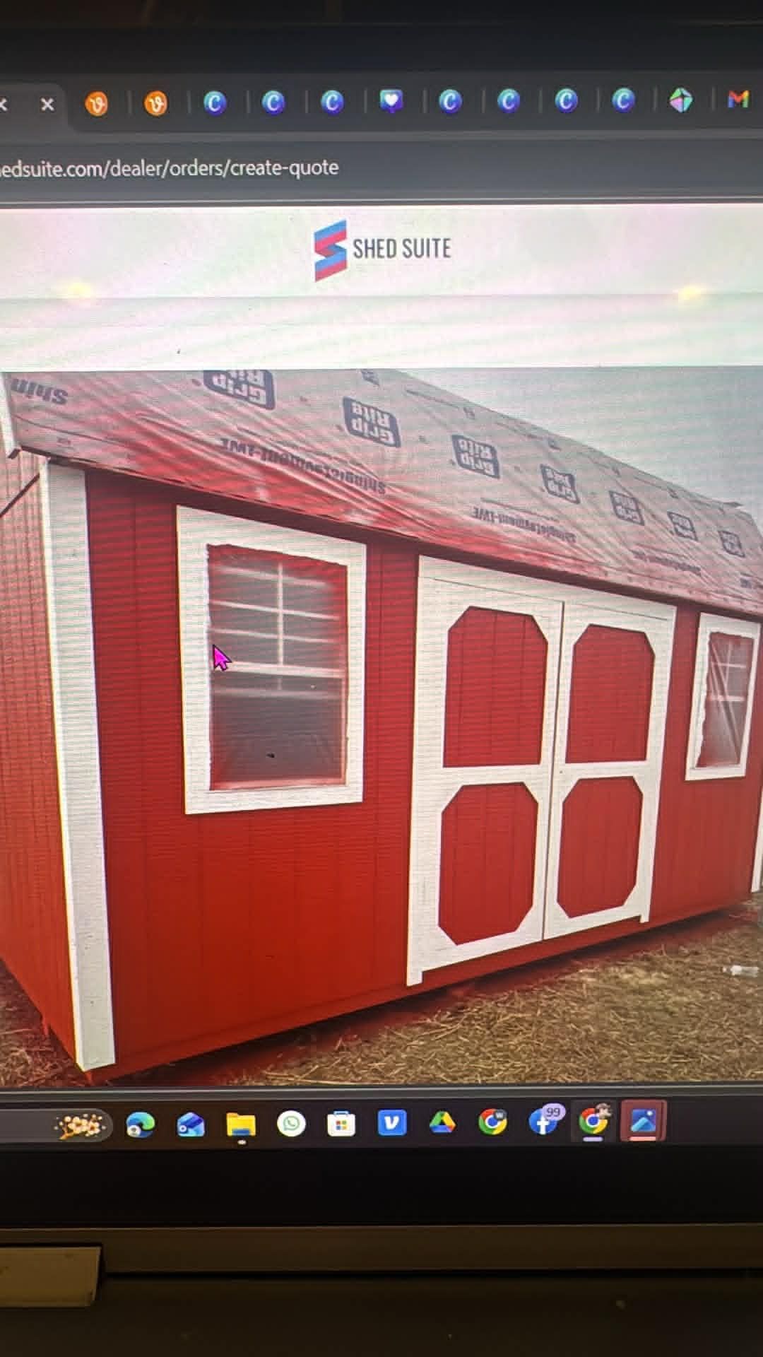 Red garden shed with white-trimmed windows and double doors, viewed from the front-left angle.