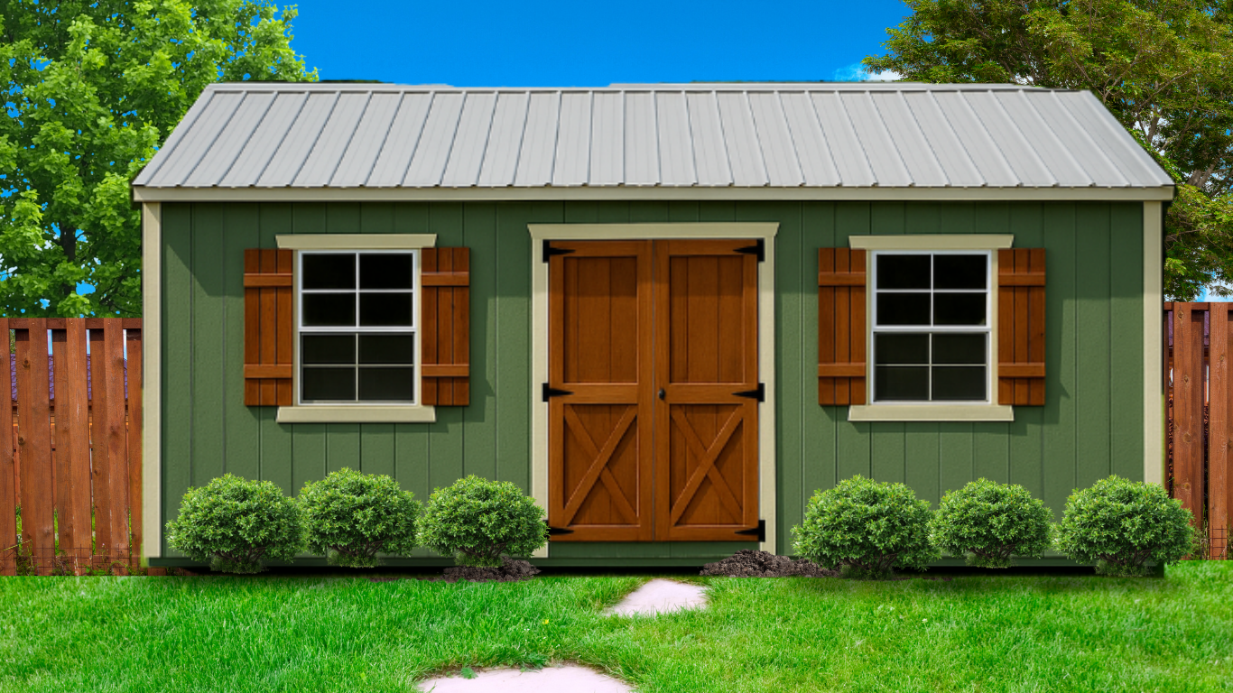 A green backyard shed with a silver metal roof, brown doors, and windows with shutters, set in a grassy yard.
