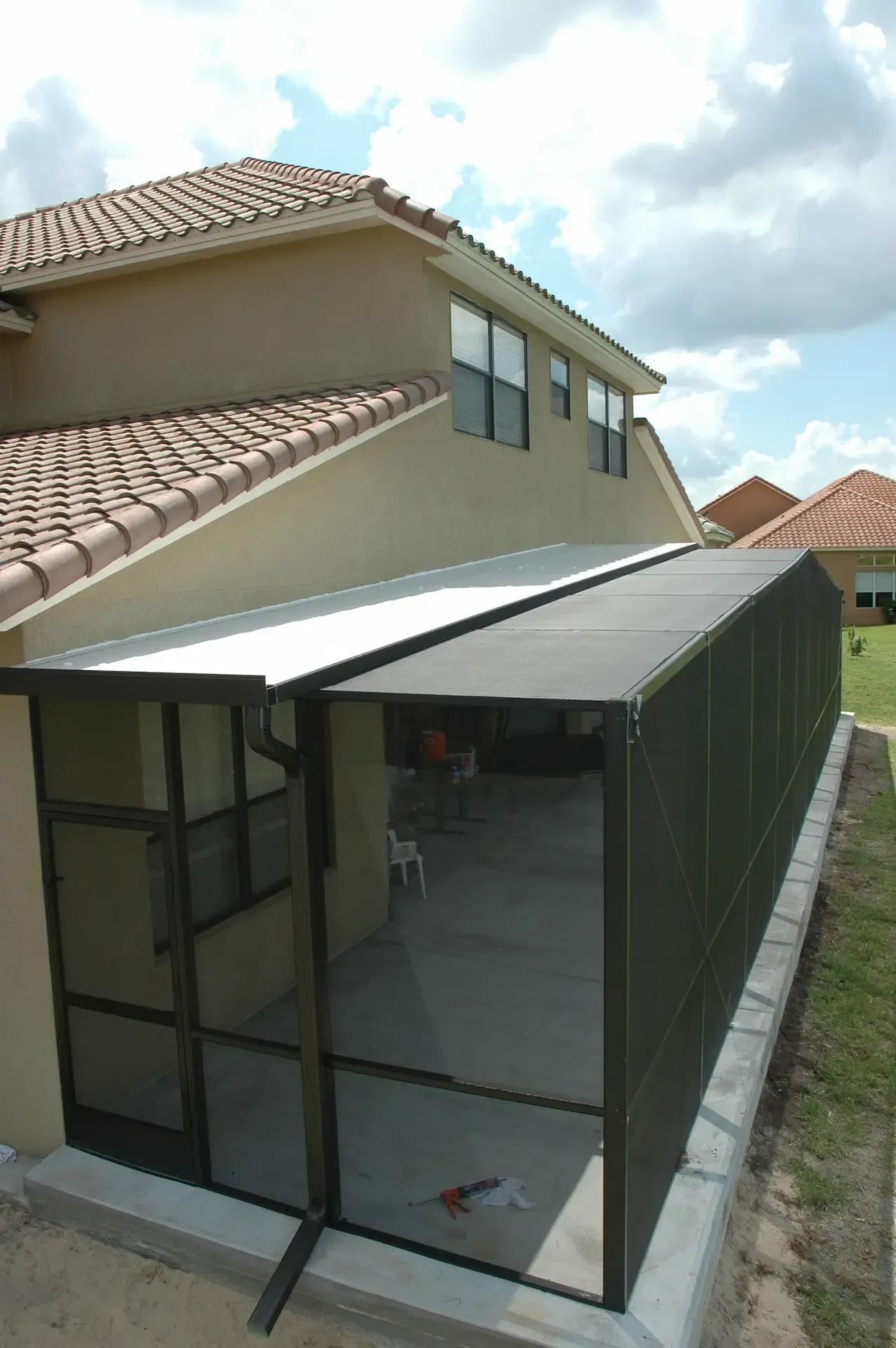 A house with a screened in porch and a roof