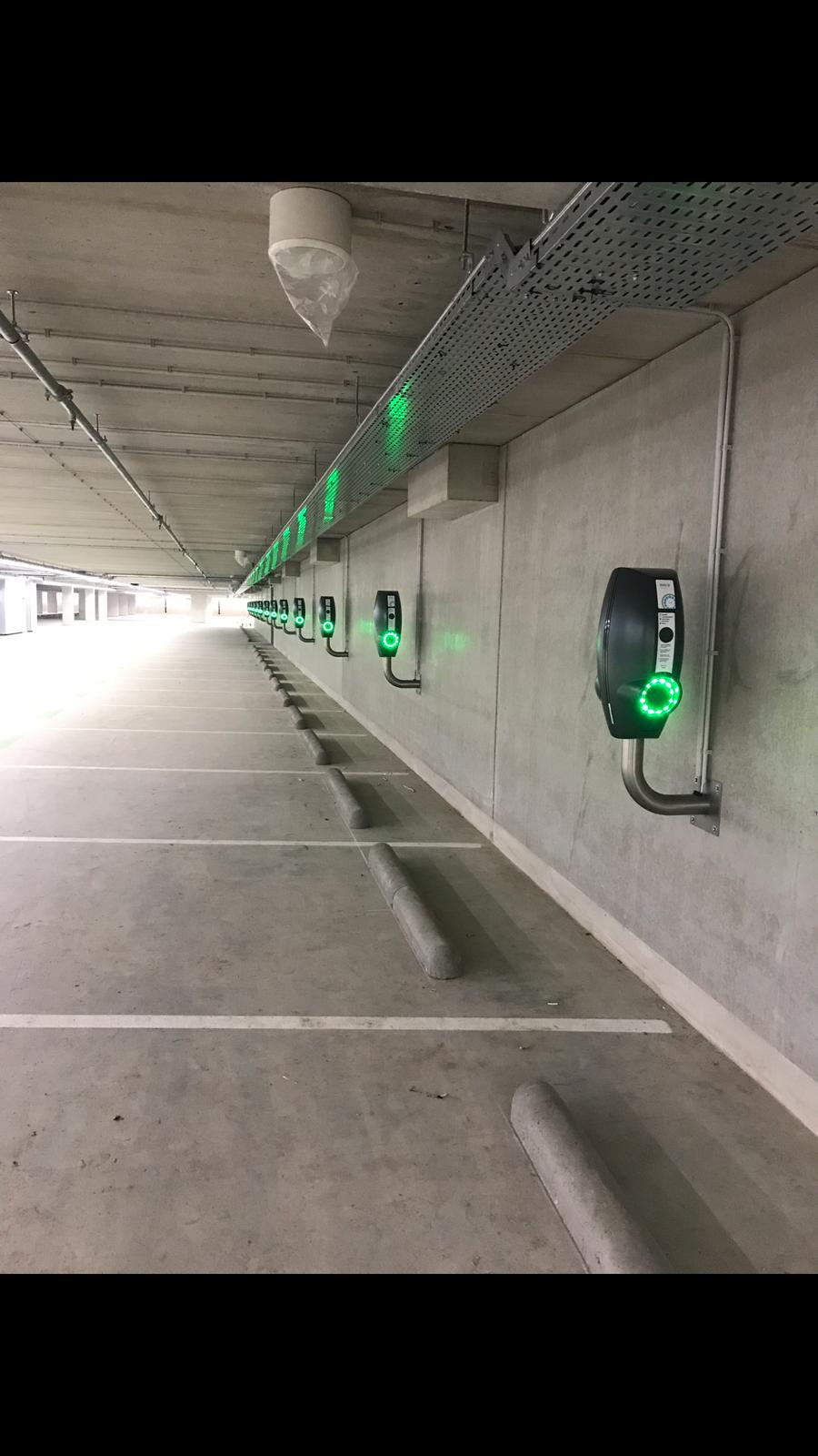 Een parkeergarage met laadpalen aan de wand