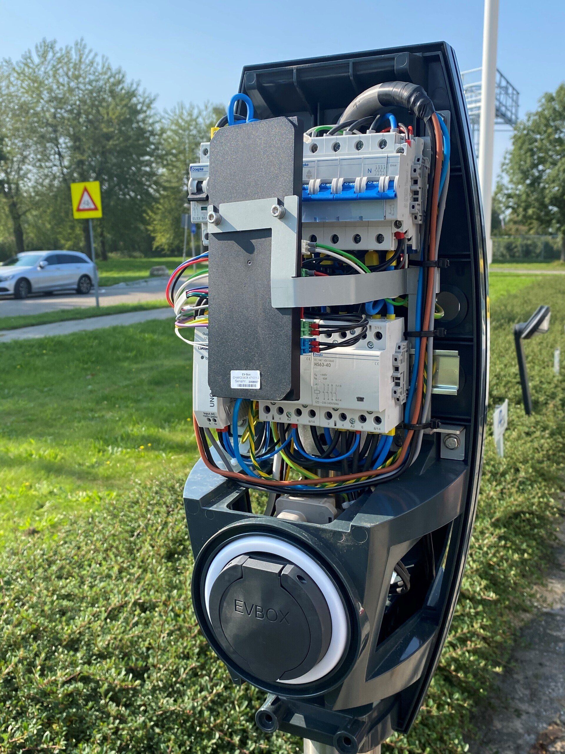 De binnenkant van een laadstation waar veel draden uit komen.