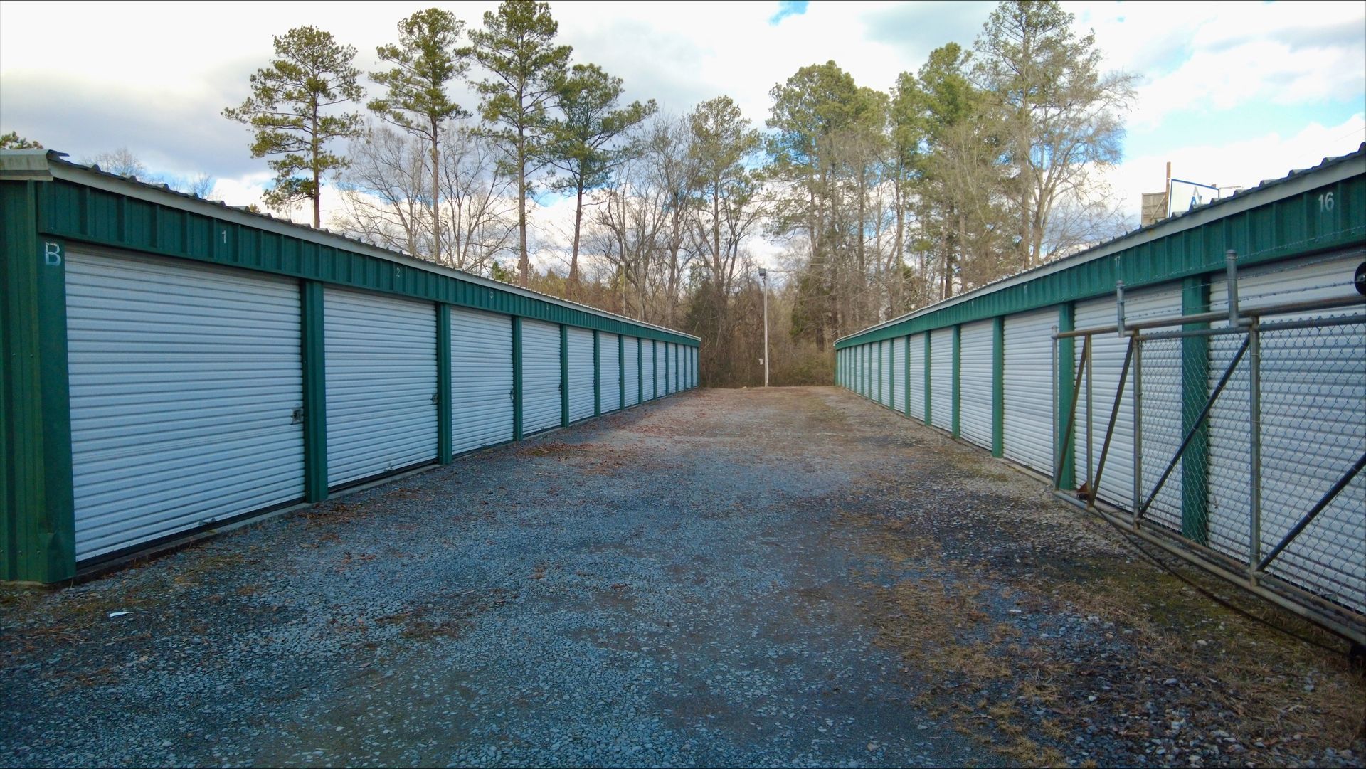 An empty storage room with green doors and a green railing - Rome, GA - Armuchee Self Storage
