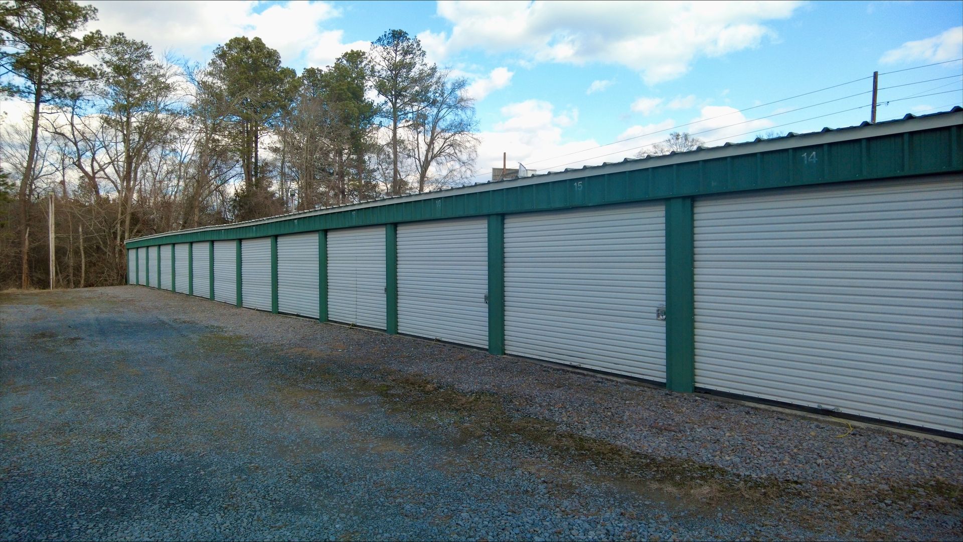 A long hallway with green doors in a warehouse - Rome, GA - Armuchee Self Storage
