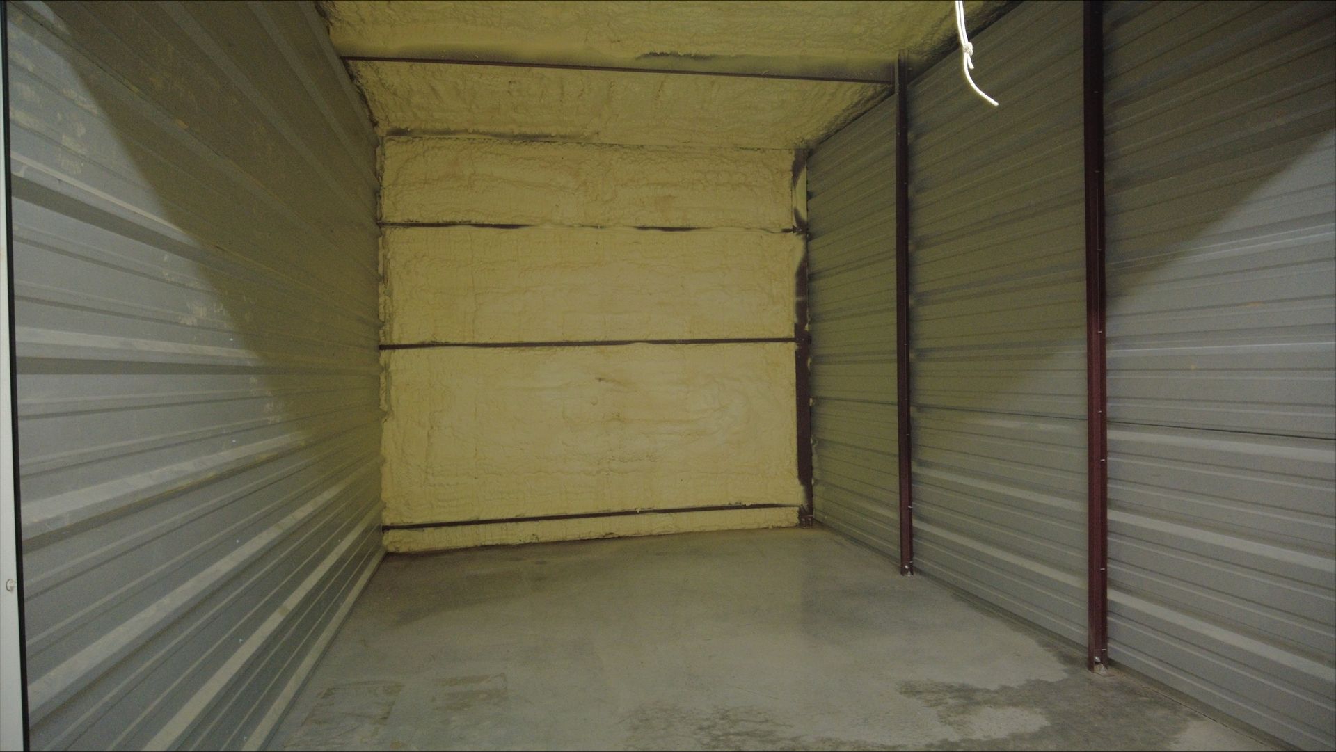 A small empty room with a metal wall and a concrete floor - Rome, GA - Armuchee Self Storage