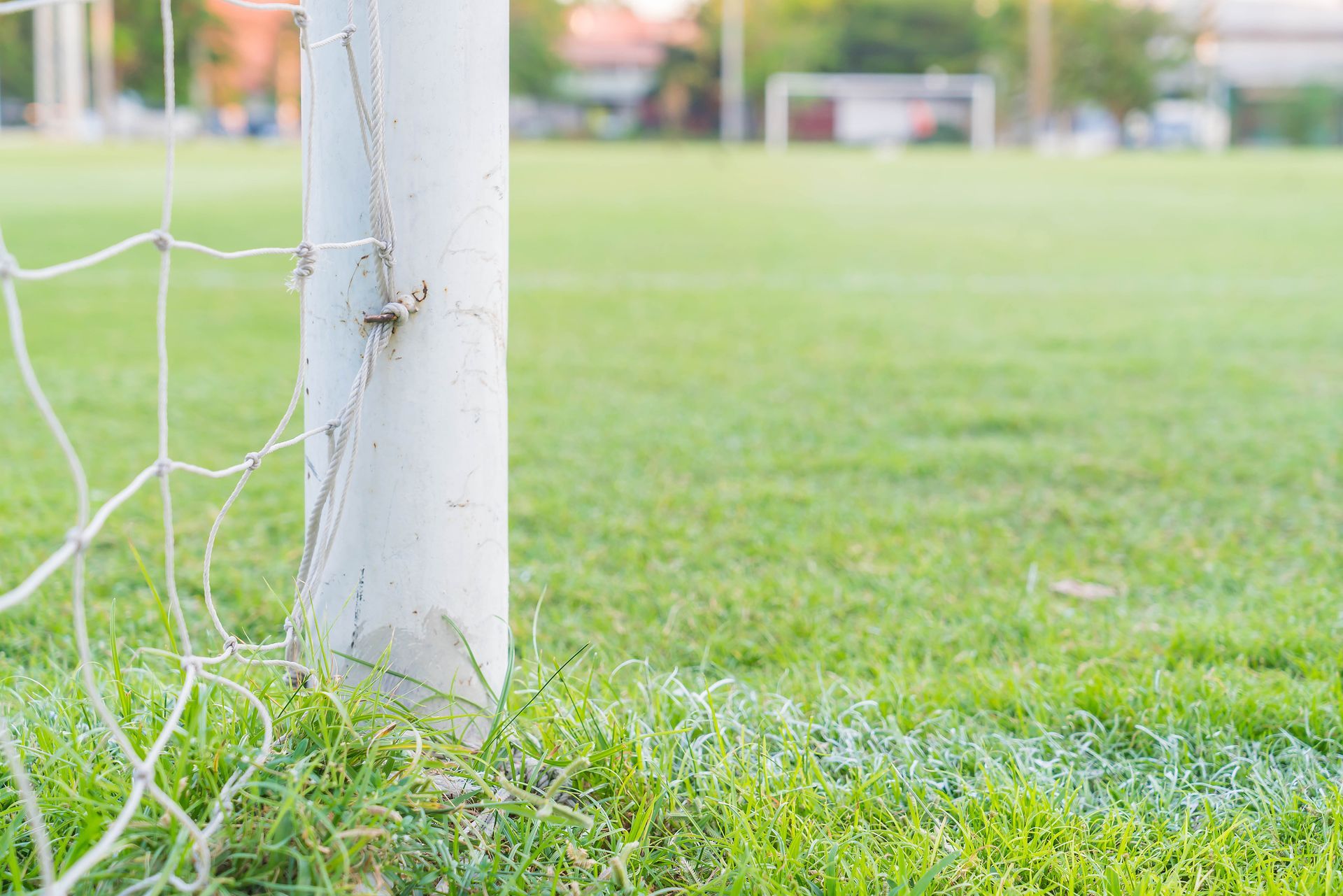 A close up of a soccer goal post on a soccer field.