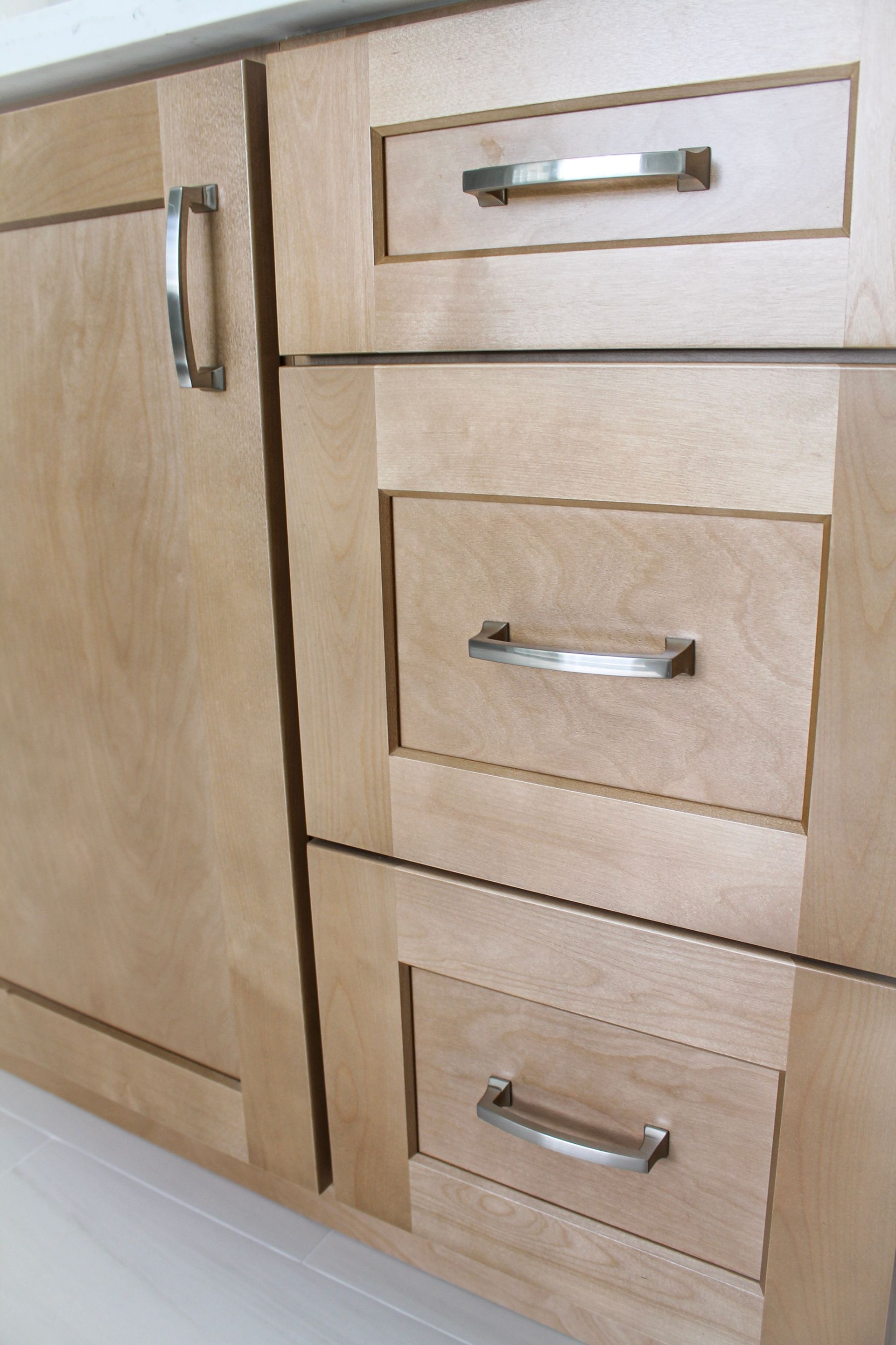 Honey wood colored shaker cabinets with modern brushed silver handles 