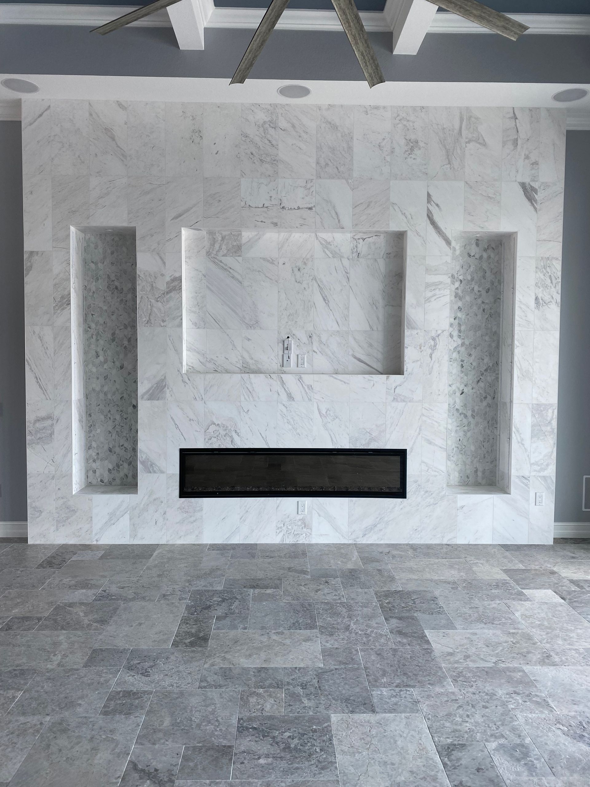 a tile wall with cutouts and gray flooring