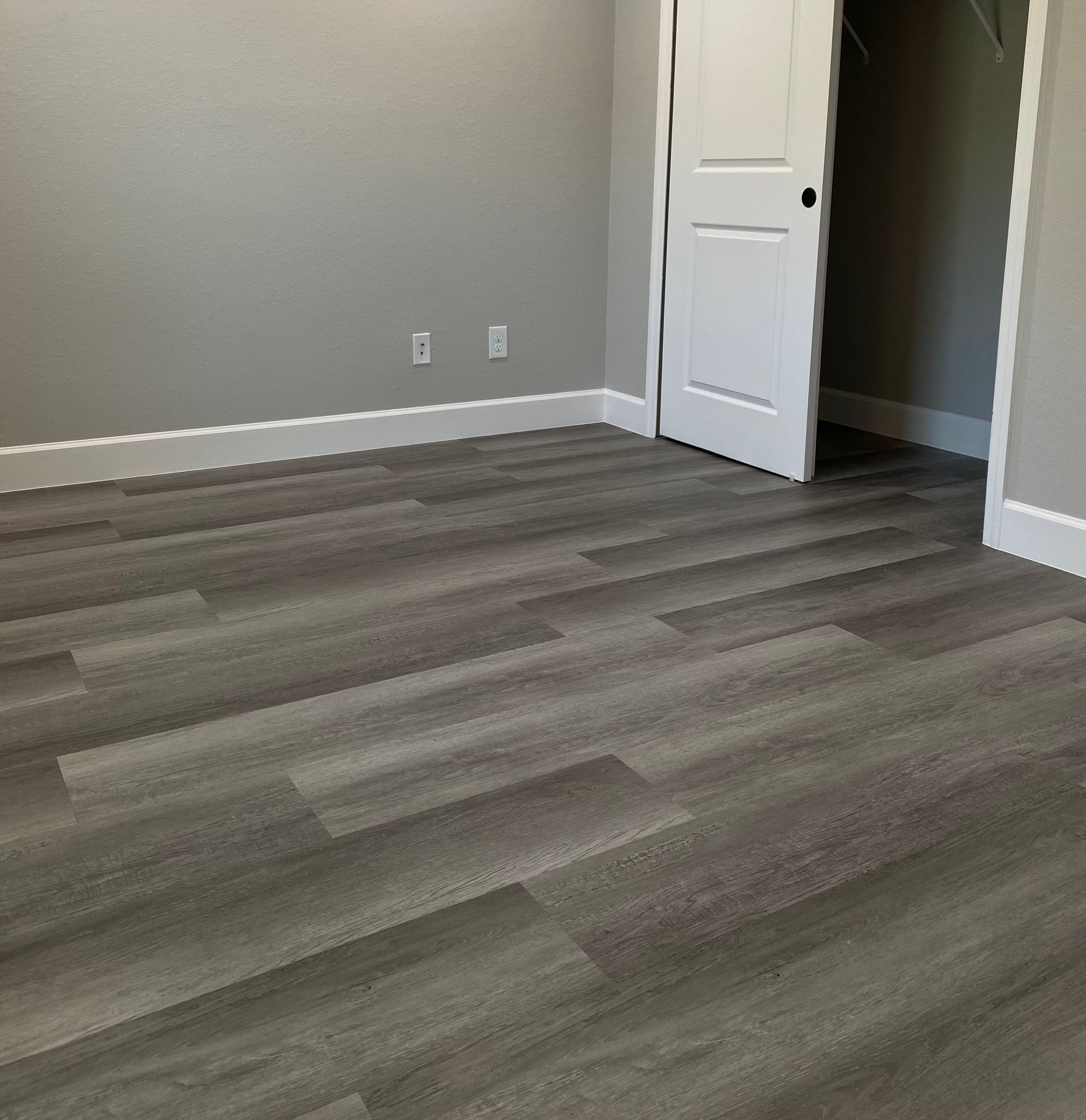 A hallway with hardwood floors and stairs in a house.