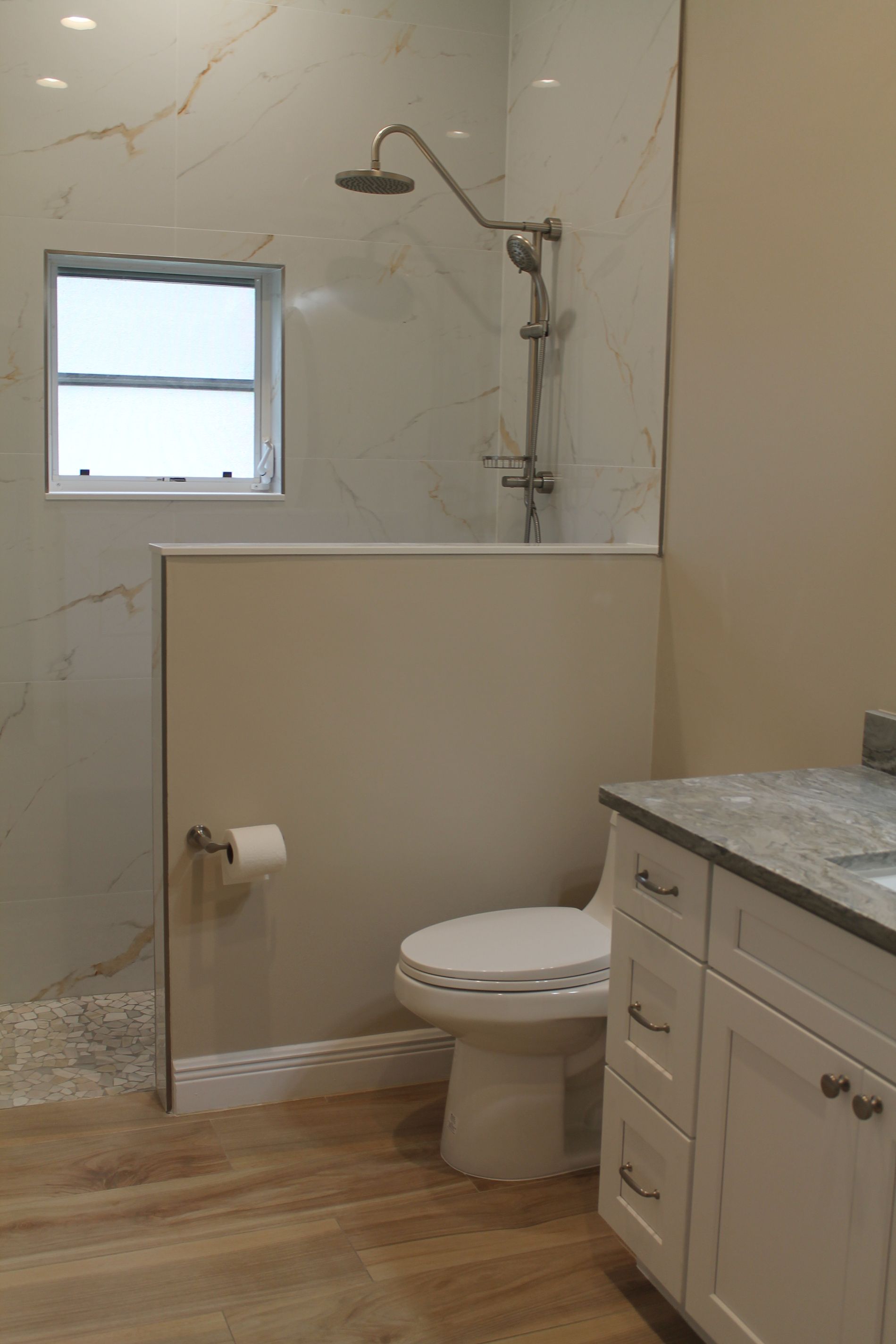 A bathroom with a toilet , sink and shower