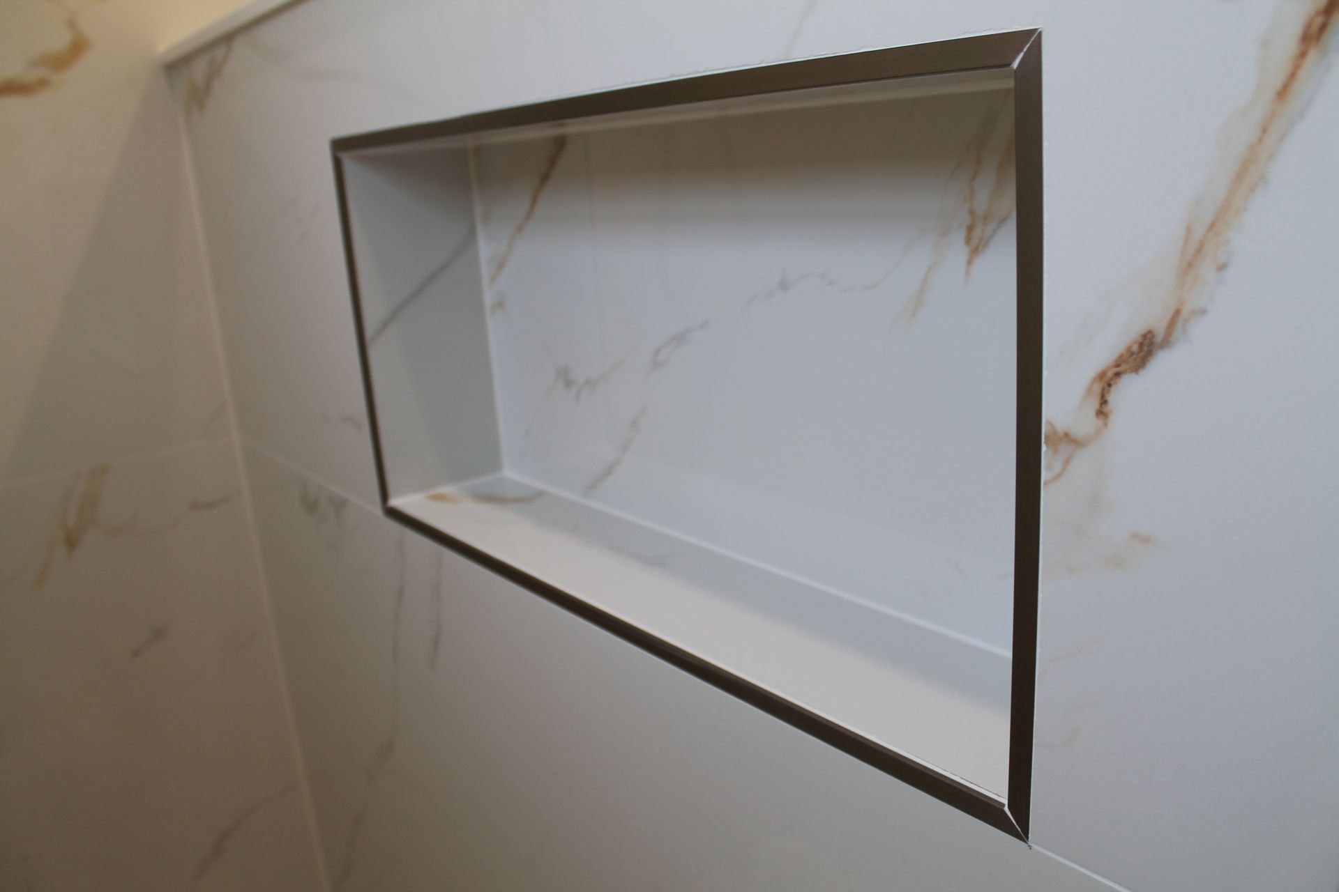 a shower with a niche tiled