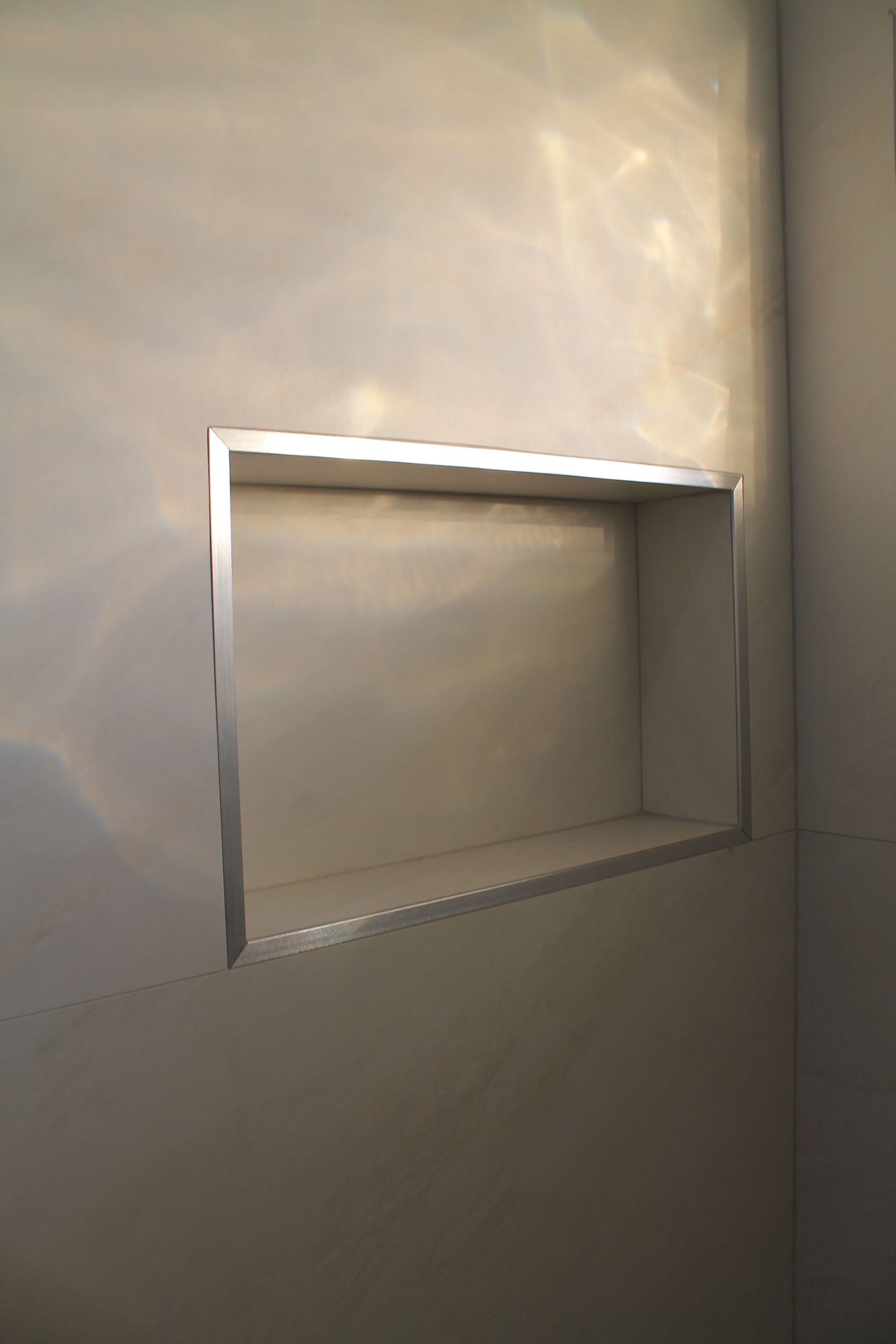 Updated bathroom shower with beige wall tile and niche