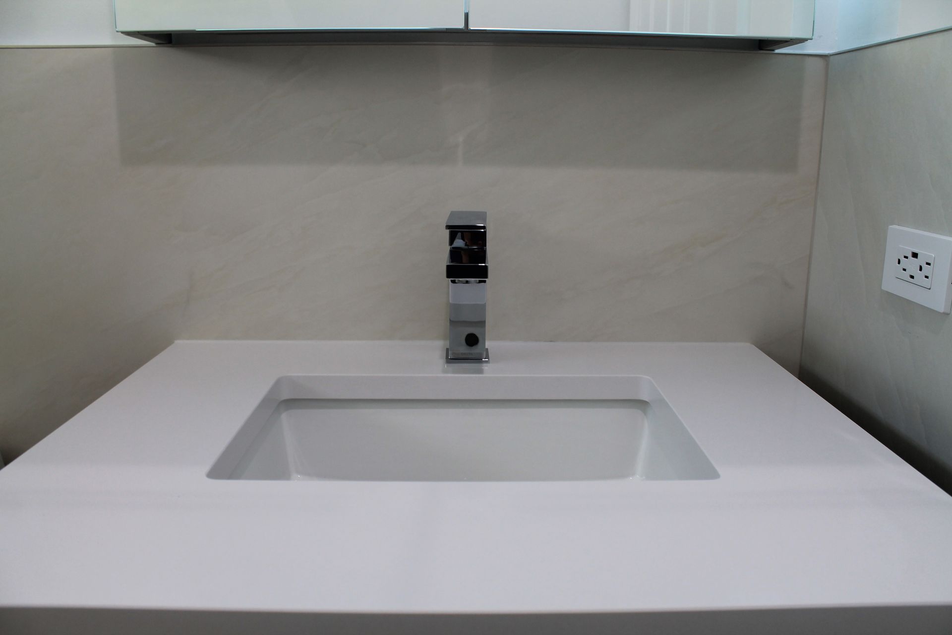 Remodeled bathroom vanity area with white quartz countertop and modern faucet
