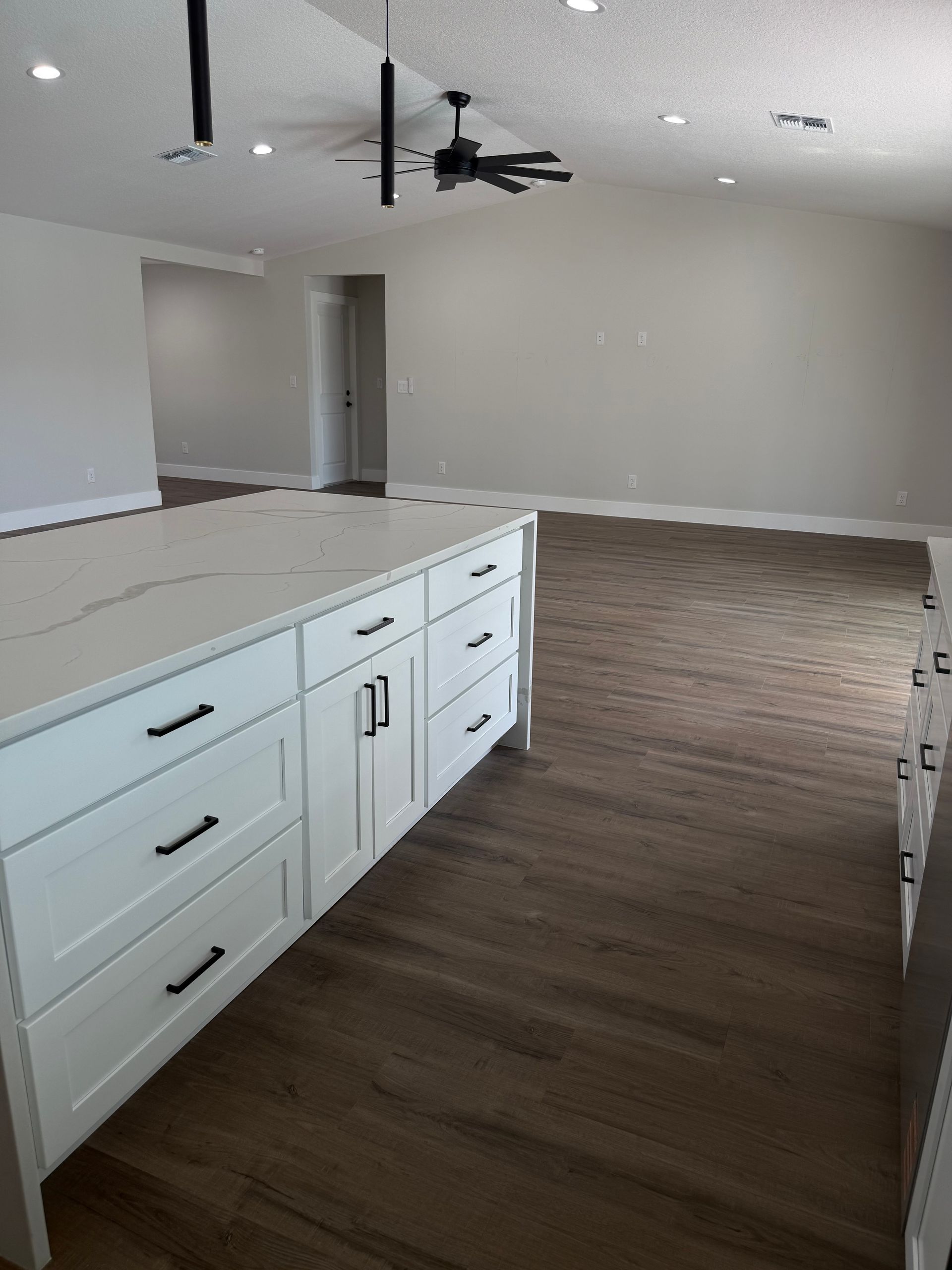White cabinets with white countertop and brown vinyl flooring