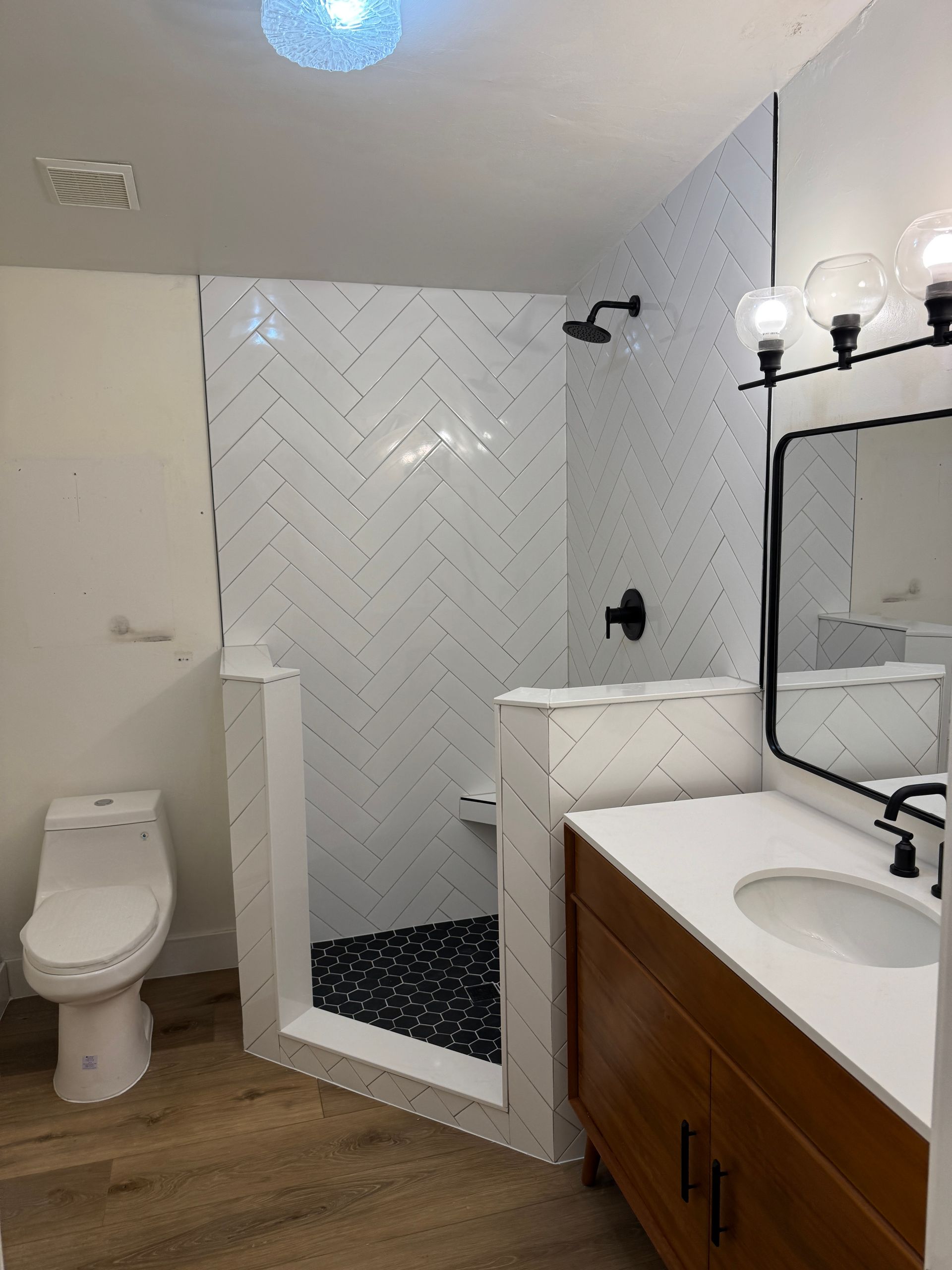 A bathroom with a toilet , sink and shower