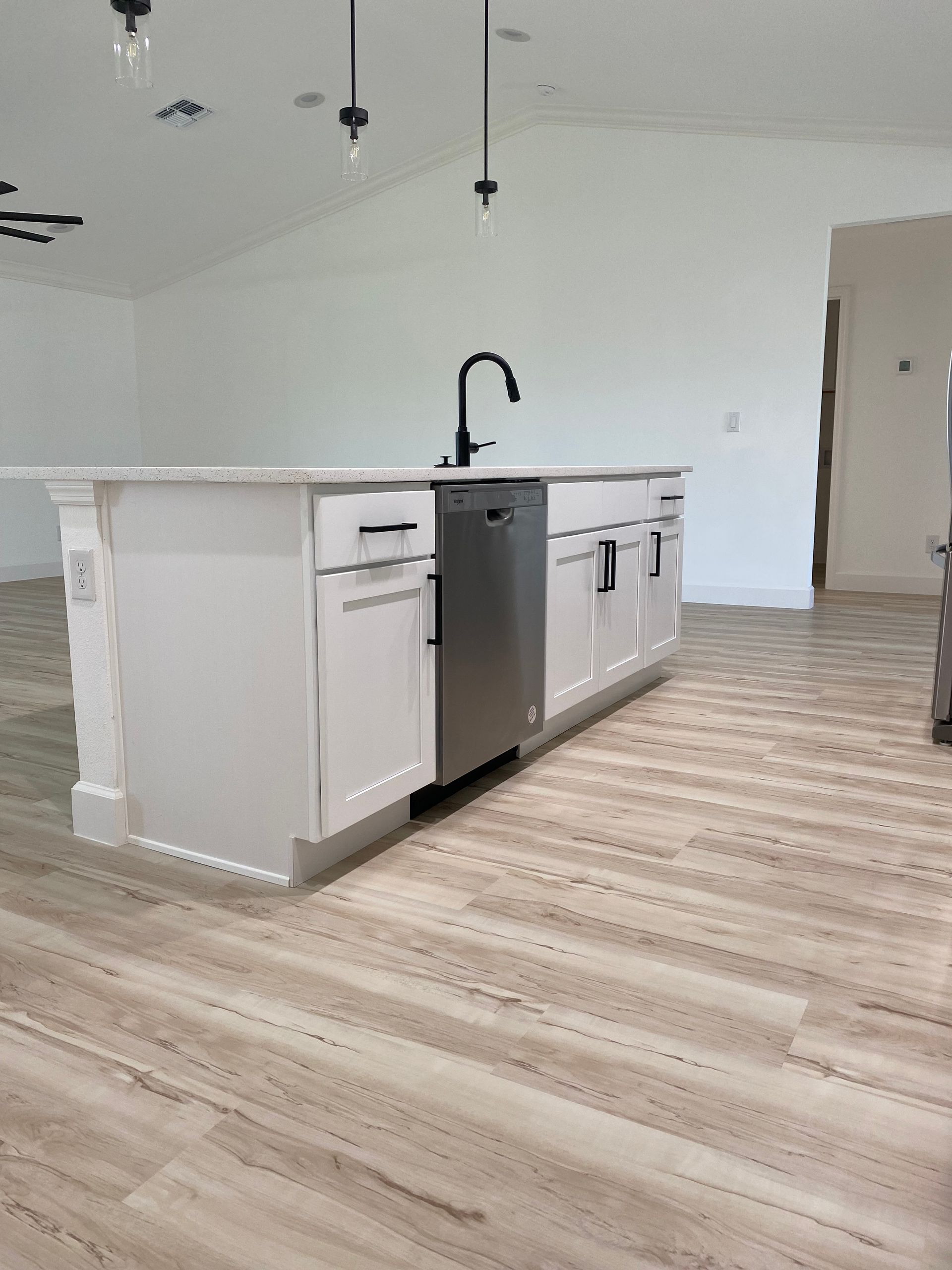 A kitchen with a large island , sink , and dishwasher.
