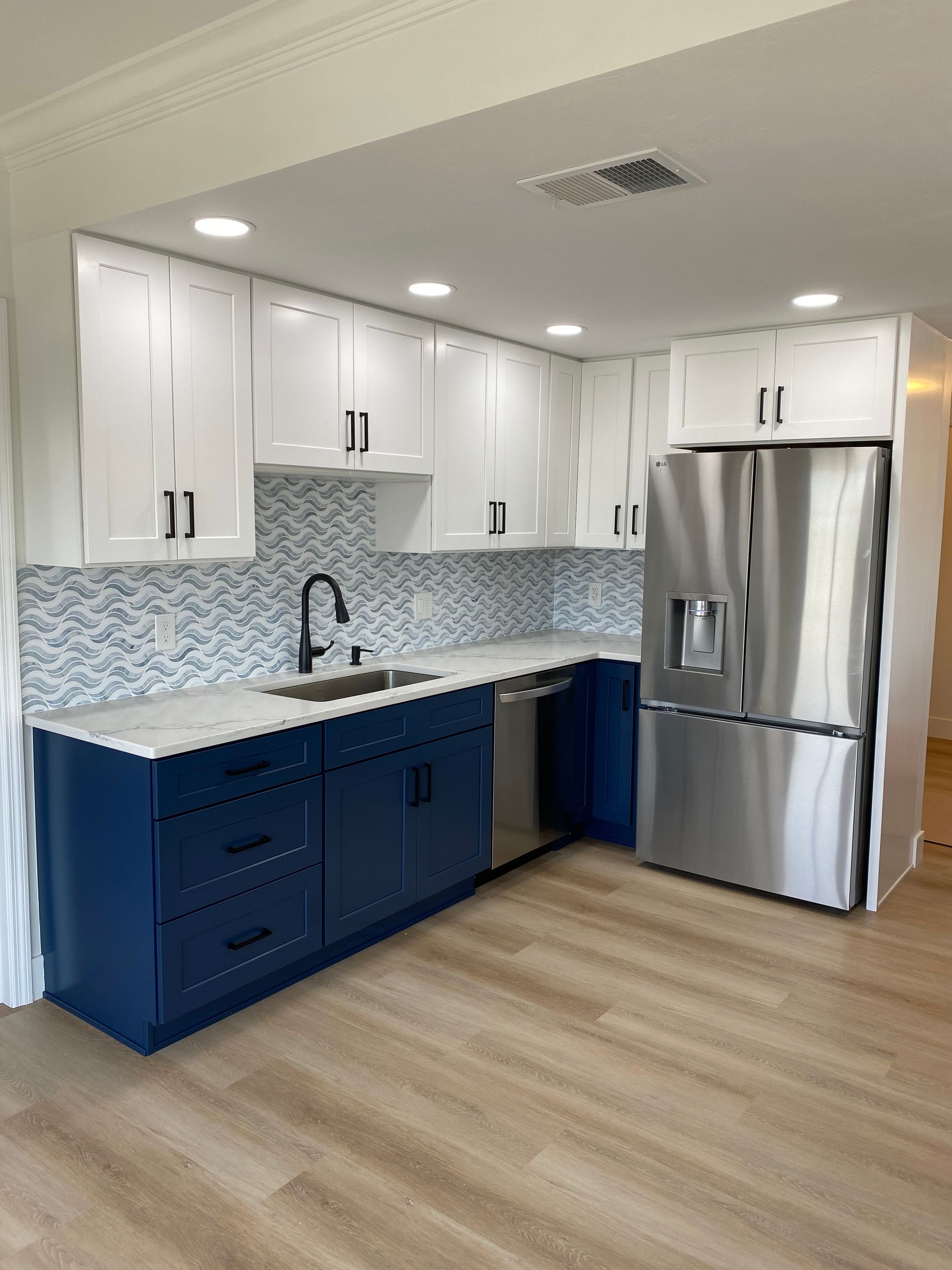 A kitchen with blue cabinets and stainless steel appliances