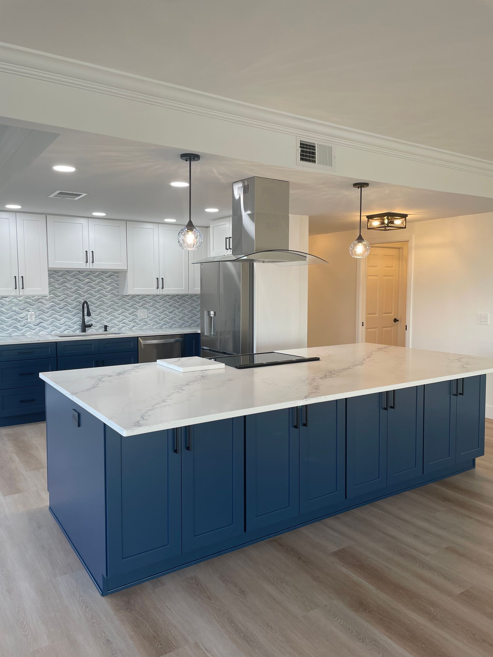A kitchen with blue cabinets and white counter tops