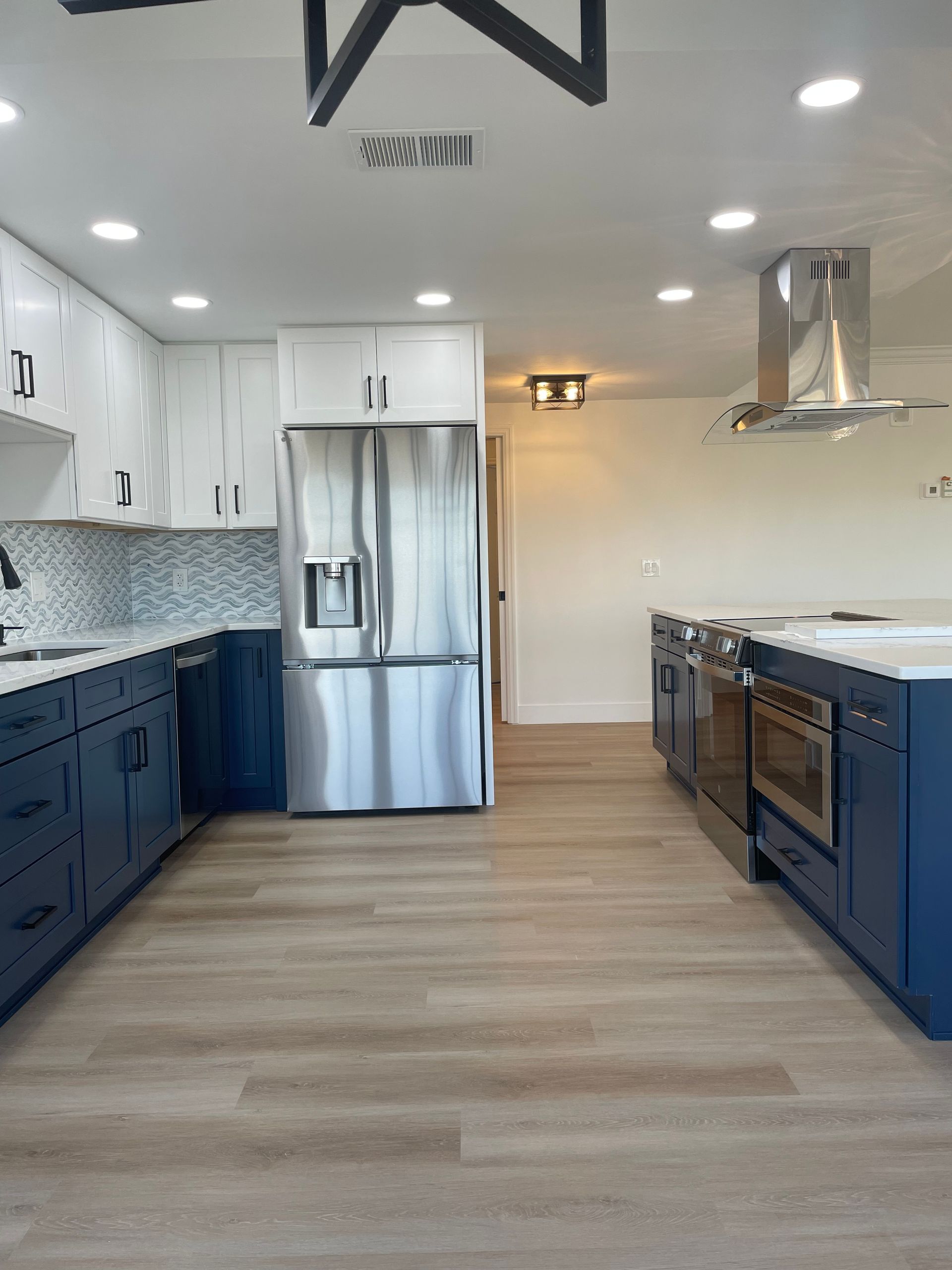 A kitchen with blue cabinets and stainless steel appliances.