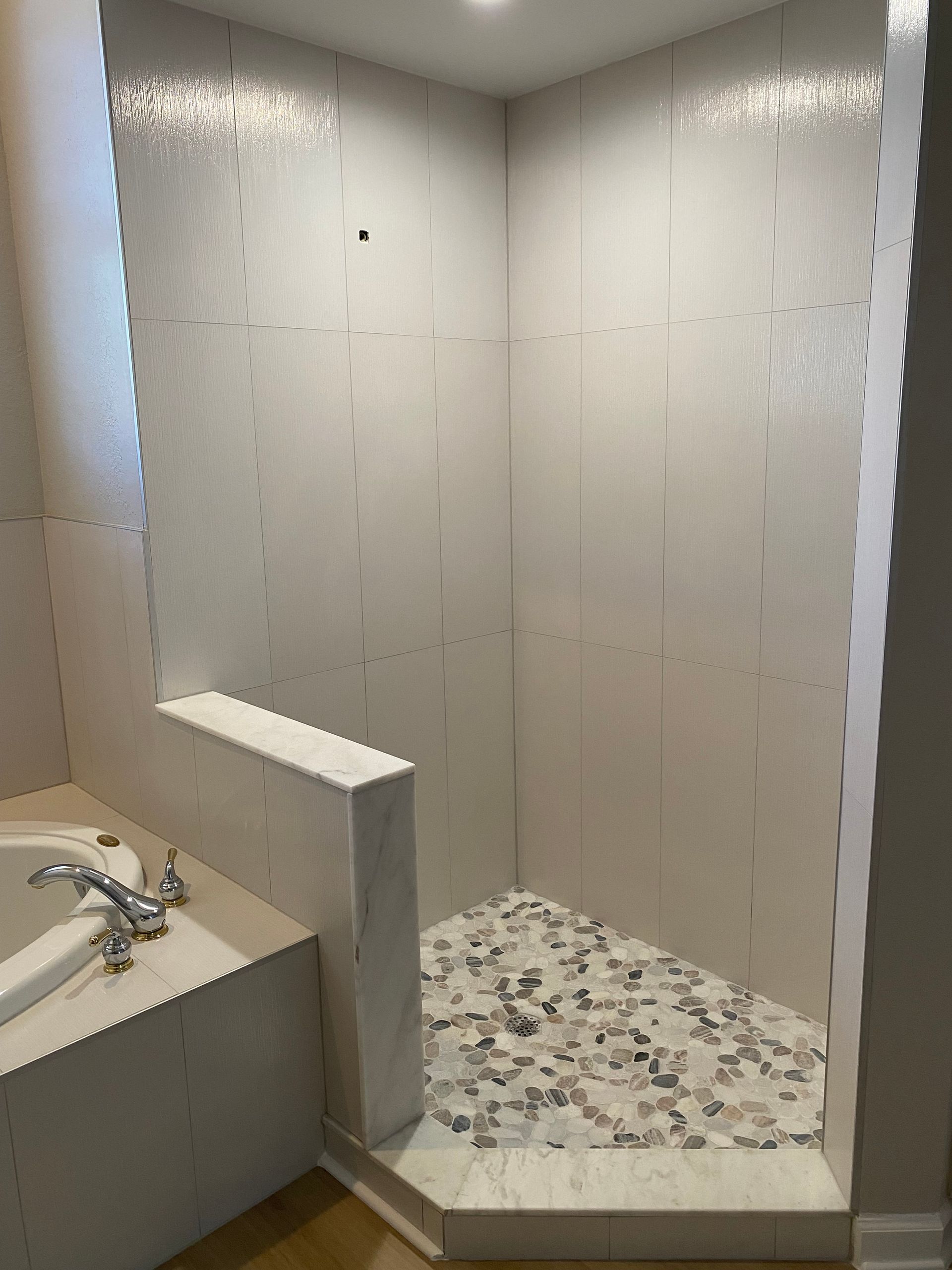 A bathroom with a bathtub and a walk in shower.