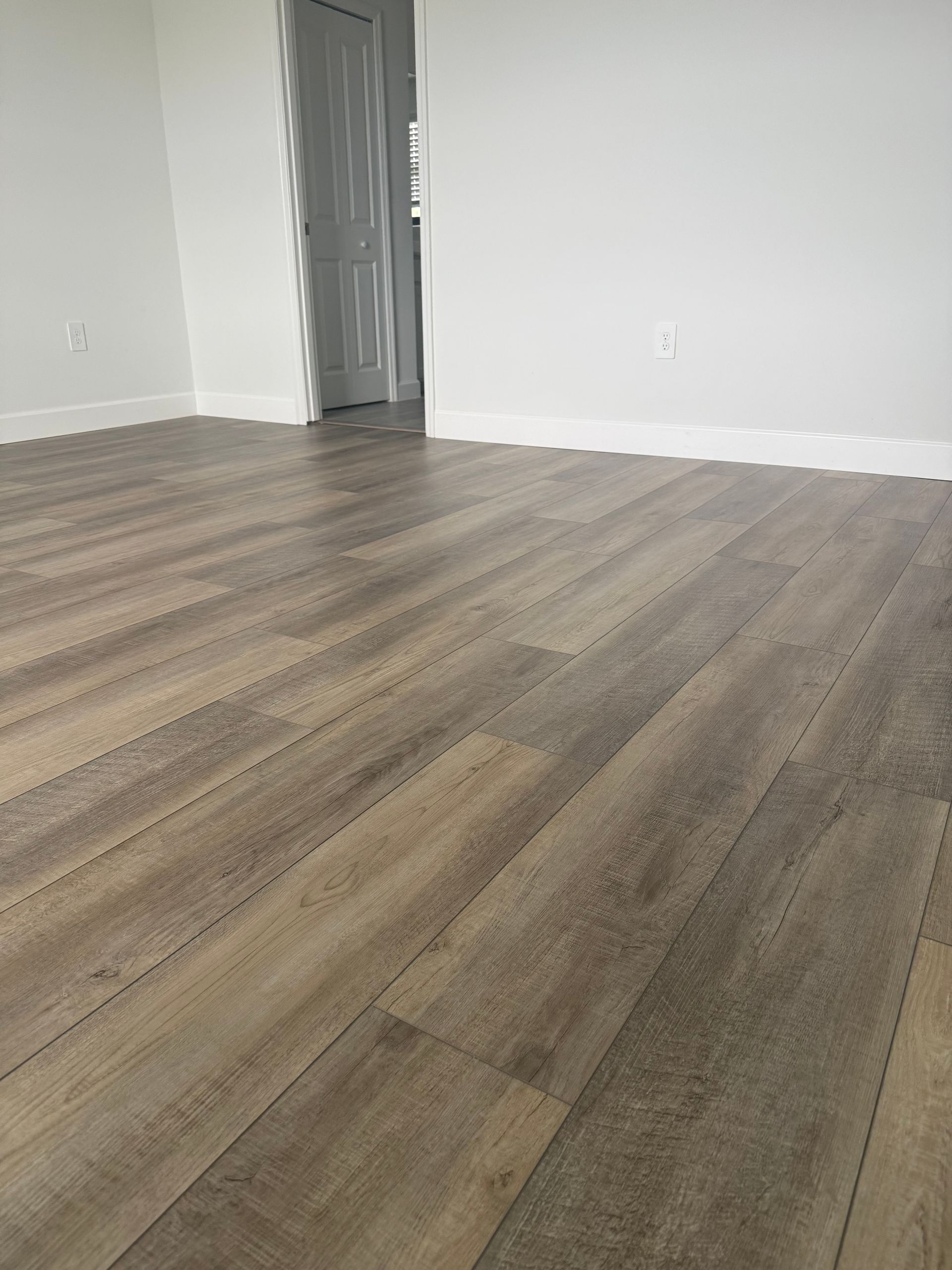 A room with a wooden floor and brown walls.