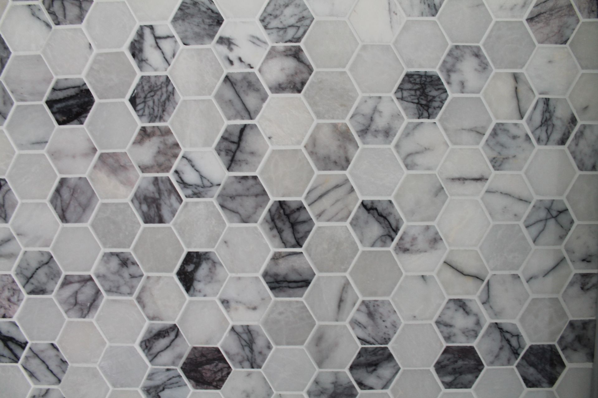 A close up of a marble tile floor with a honeycomb pattern.