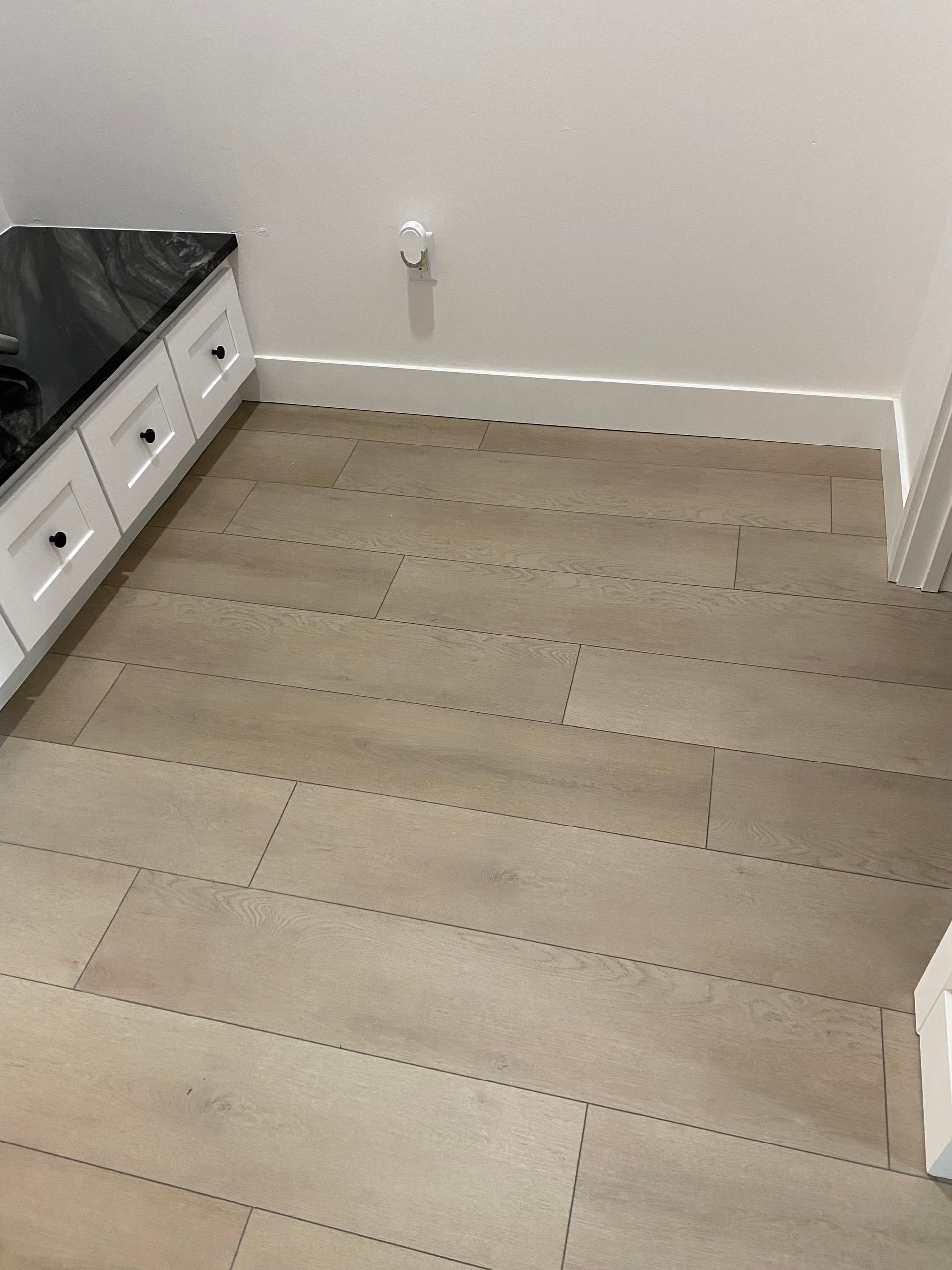 Natural beige beveled vinyl flooring 5.5mm vinyl flooring with white baseboards and white wall, natural wood look SPC flooring