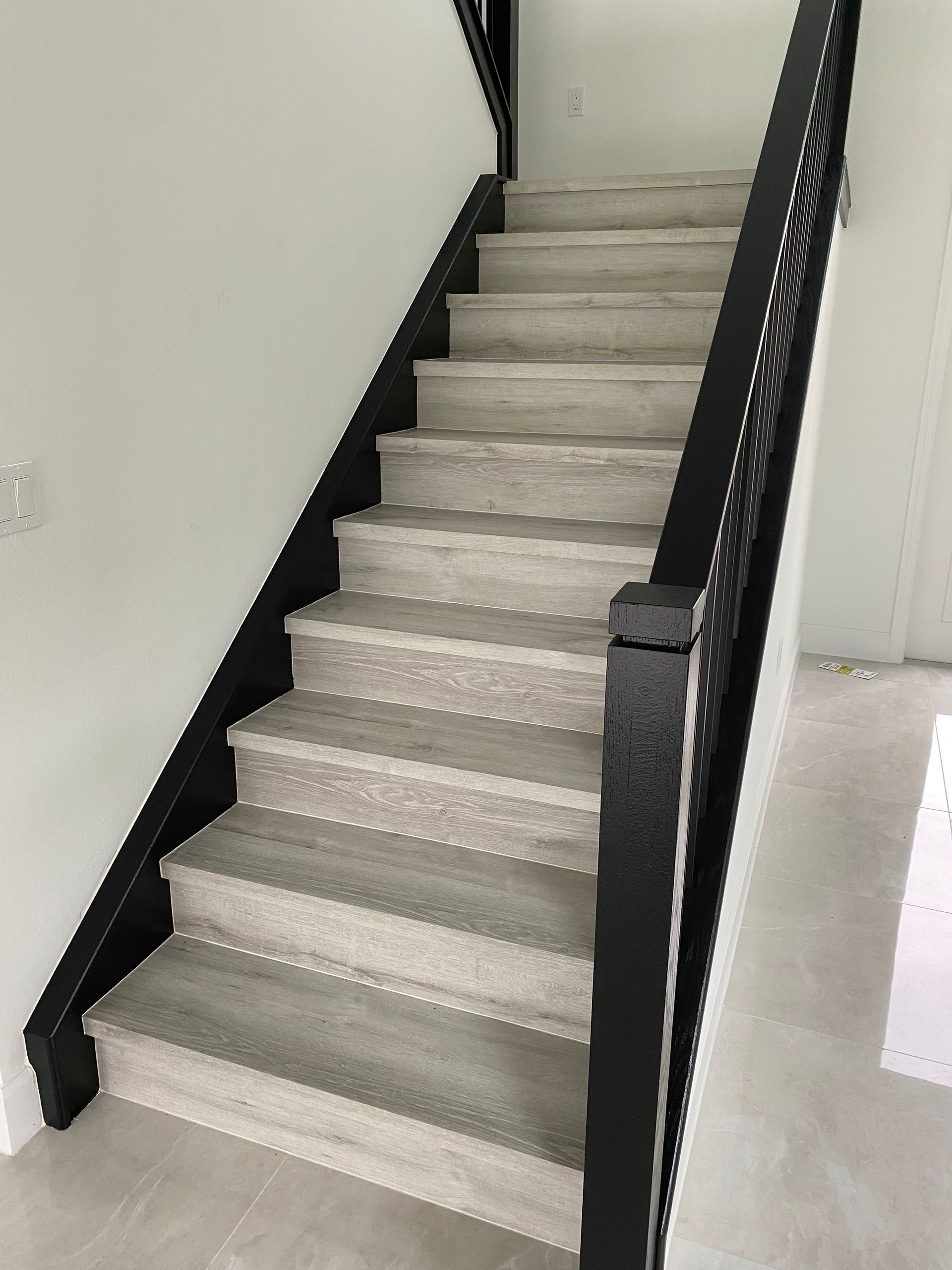 A set of stairs with a black railing in a house.