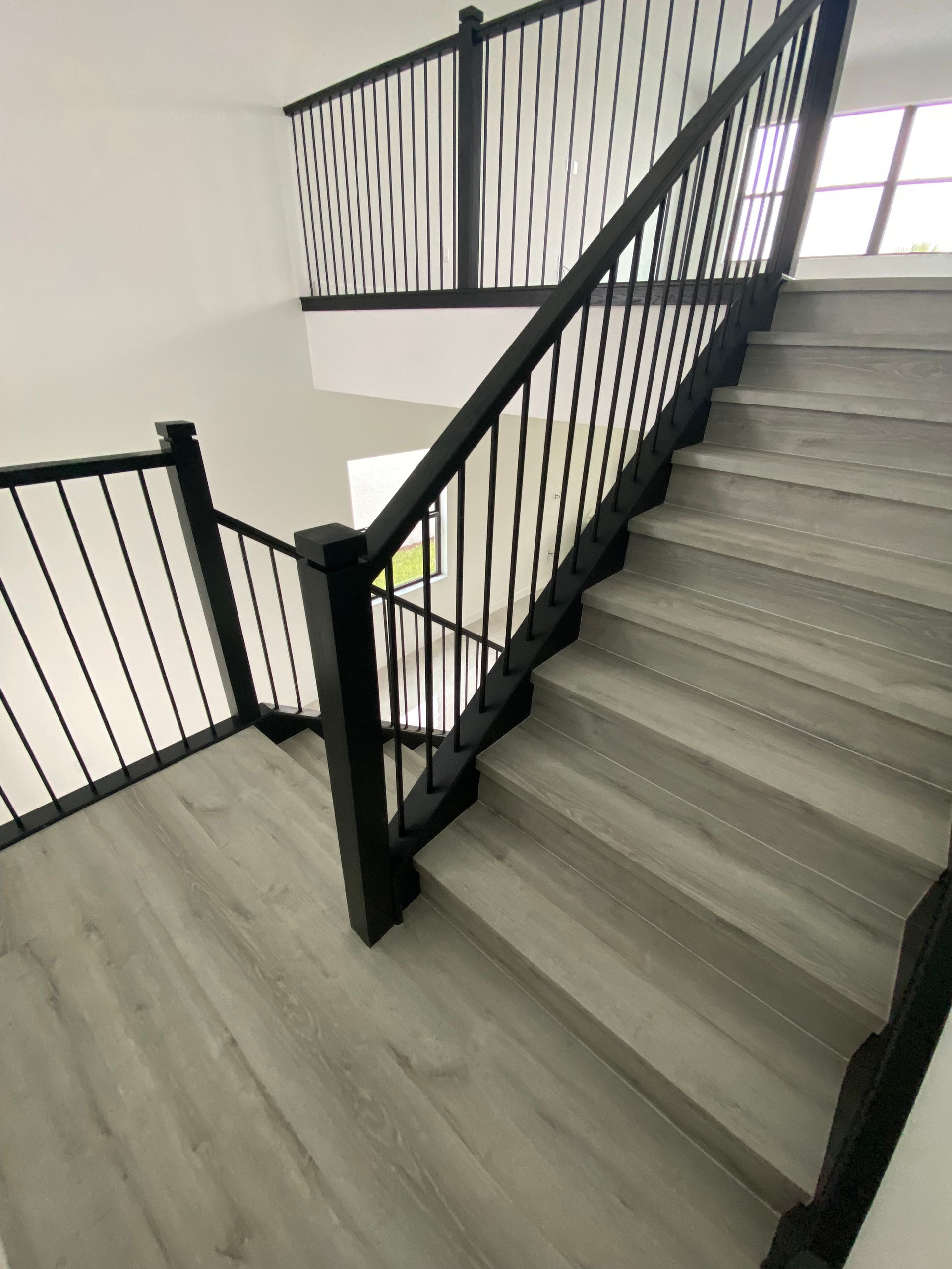A staircase with a black railing and wooden steps
