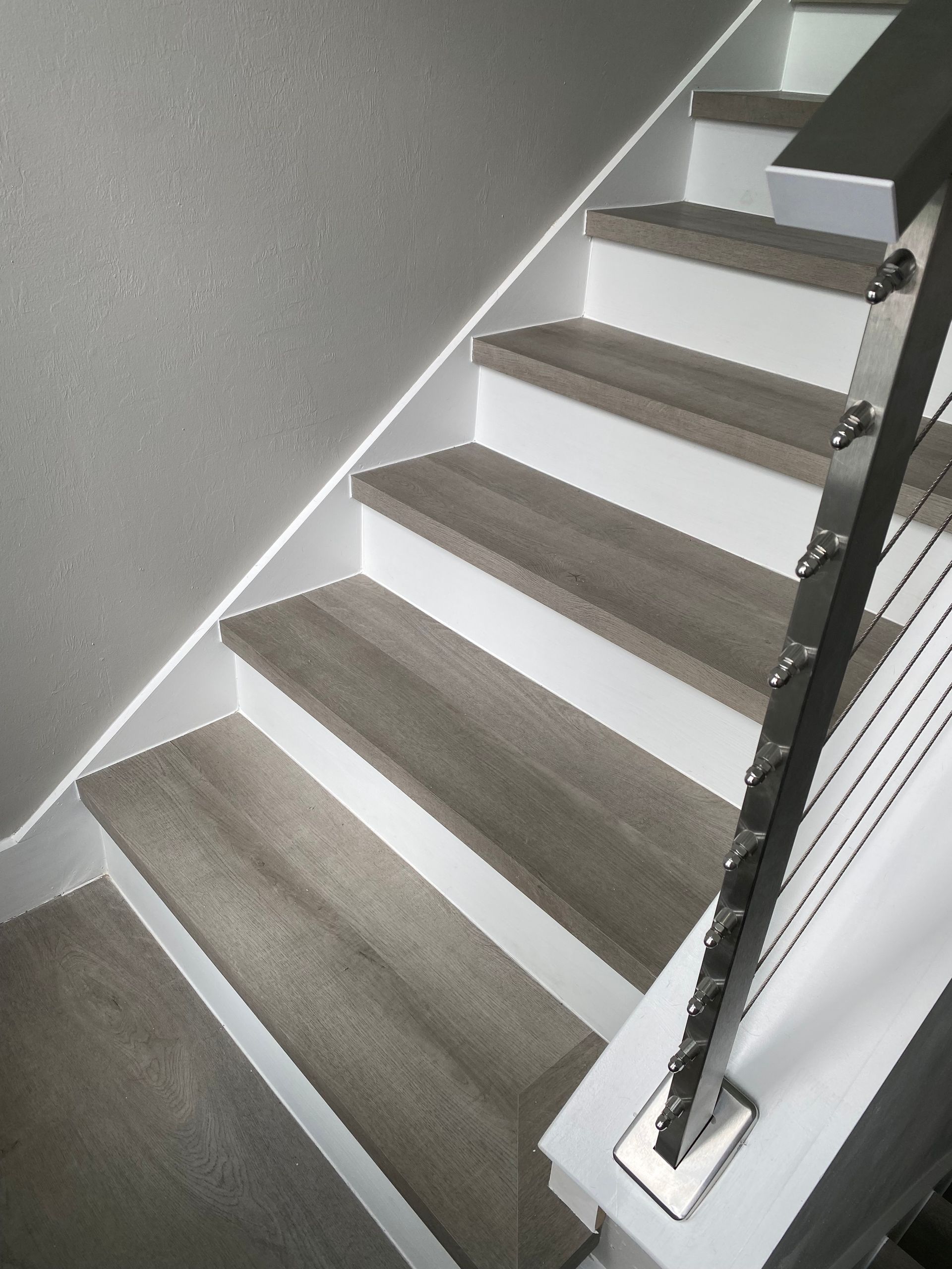 A close up of a staircase with a stainless steel railing