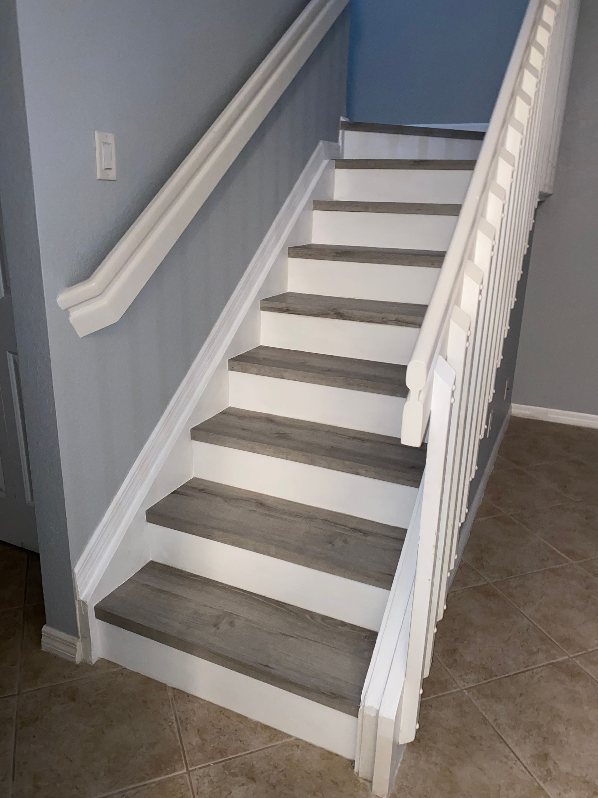 A staircase with wooden steps and a white railing in a house.