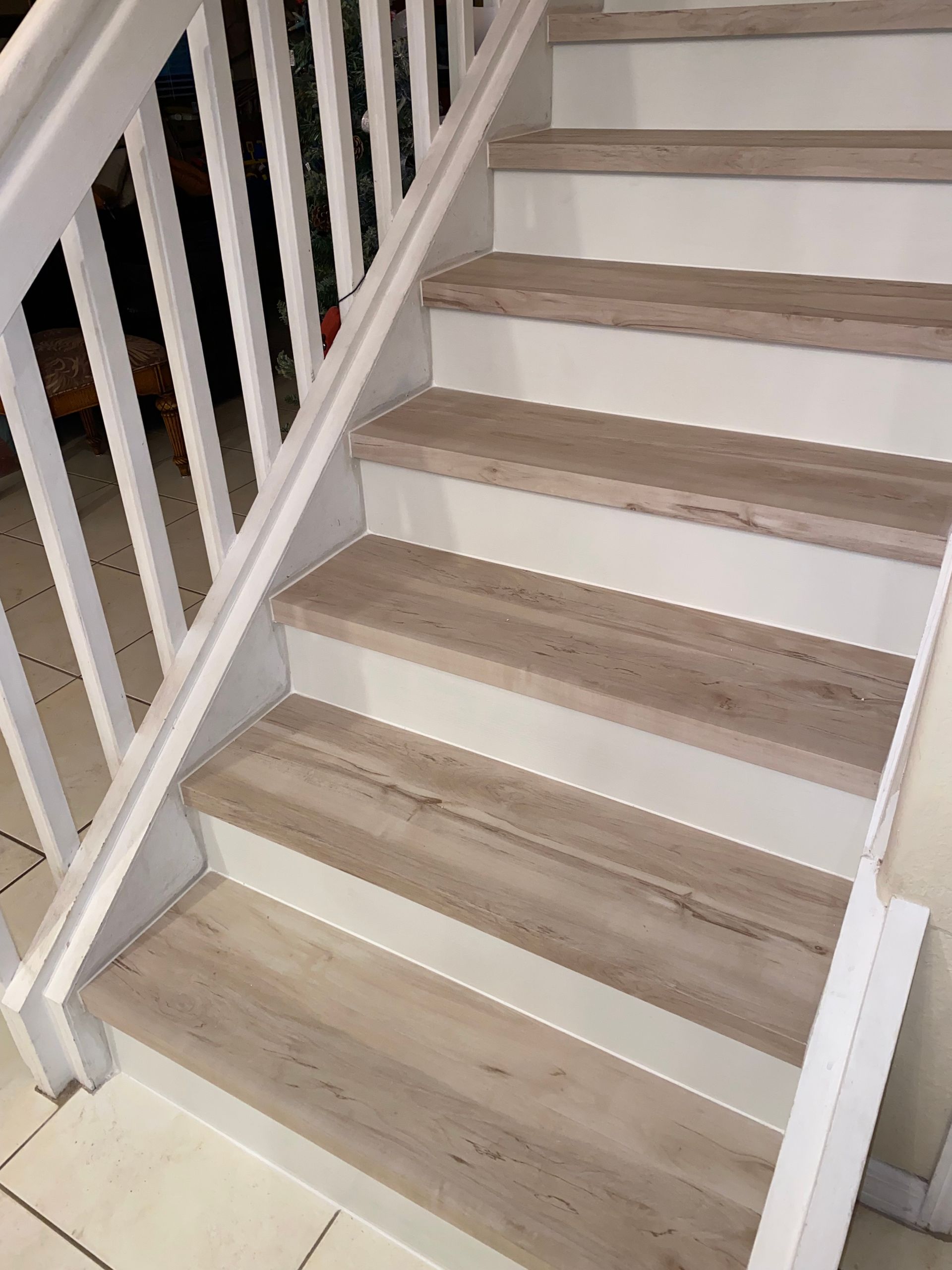 A set of stairs with wooden steps and a white railing.