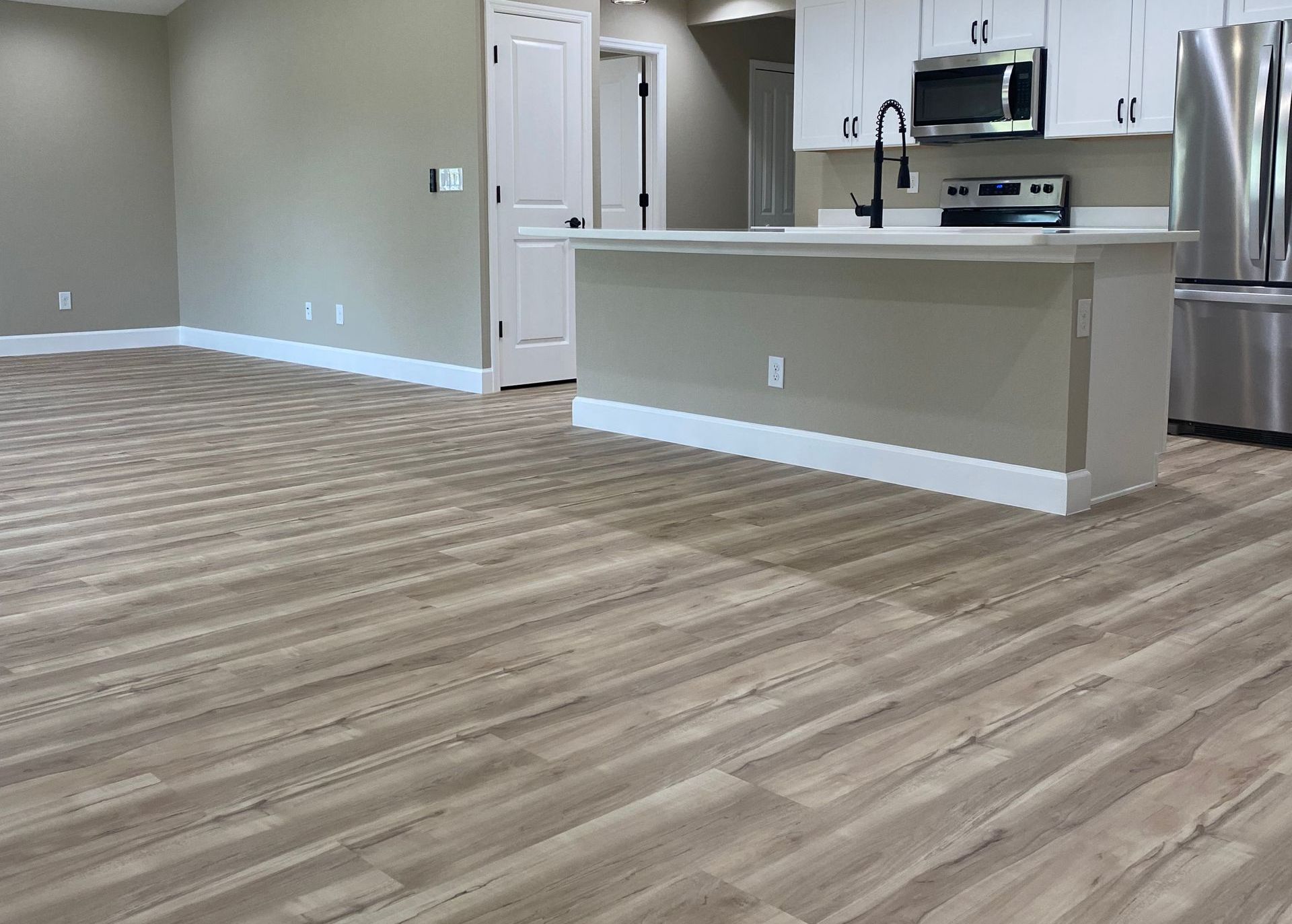 A hallway with hardwood floors and stairs in a house.