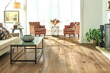 A living room with hardwood floors , a couch , chairs , coffee table and fireplace.