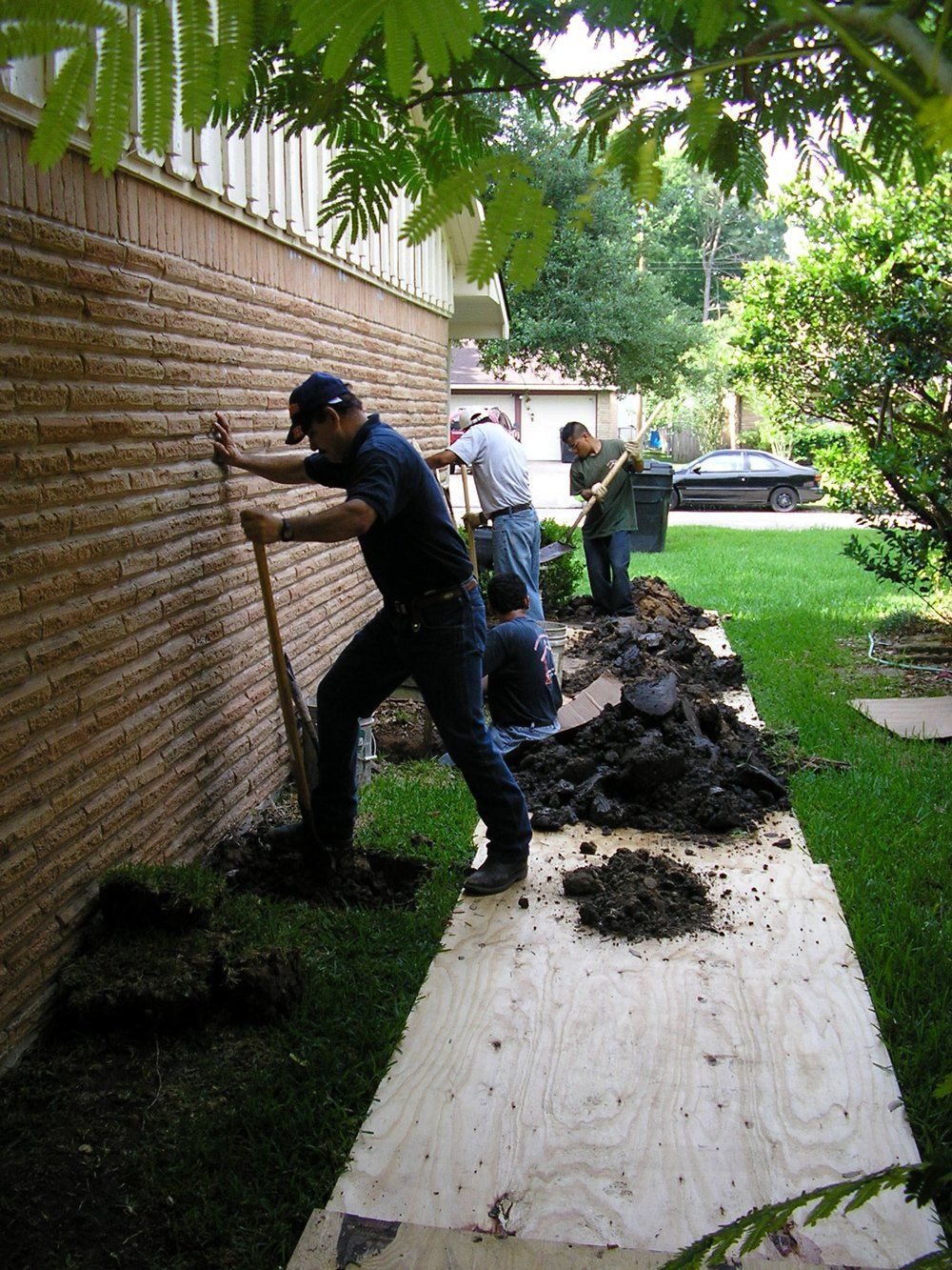 Workers Digging Near Wall — Houston, TX — Bonilla Foundation Repair