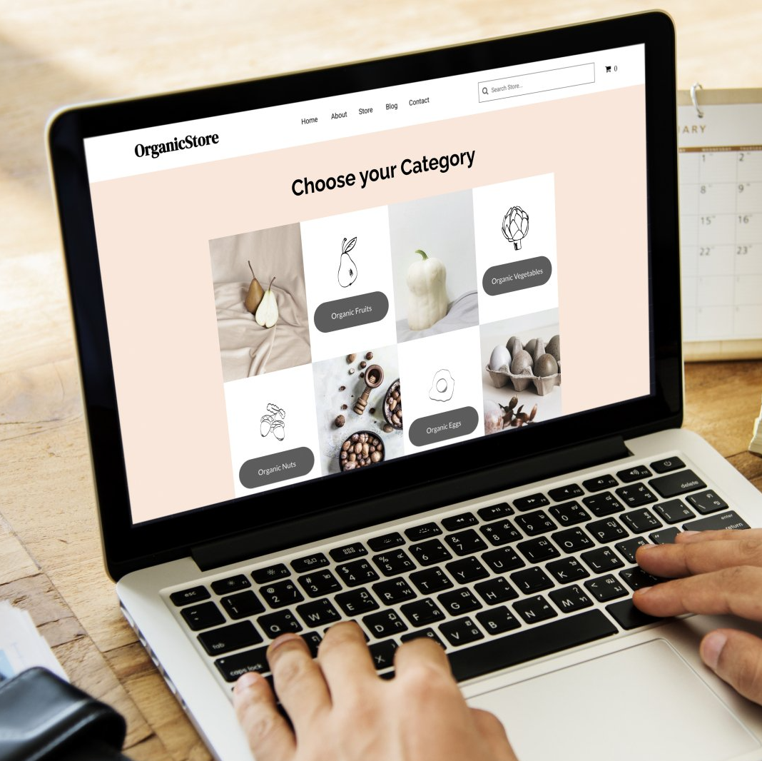Laptop displaying a website with category options. Hands typing on the keyboard.