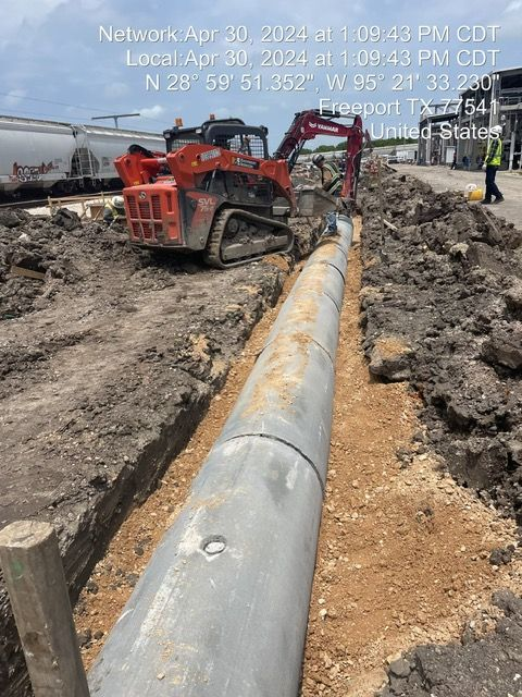 Excavator working on a buried pipe in Freeport, TX. Date and GPS coordinates displayed.