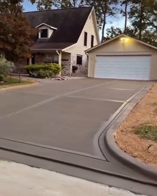 Concrete steps leading up, bordered by white walls, with a stone path and greenery in the background.