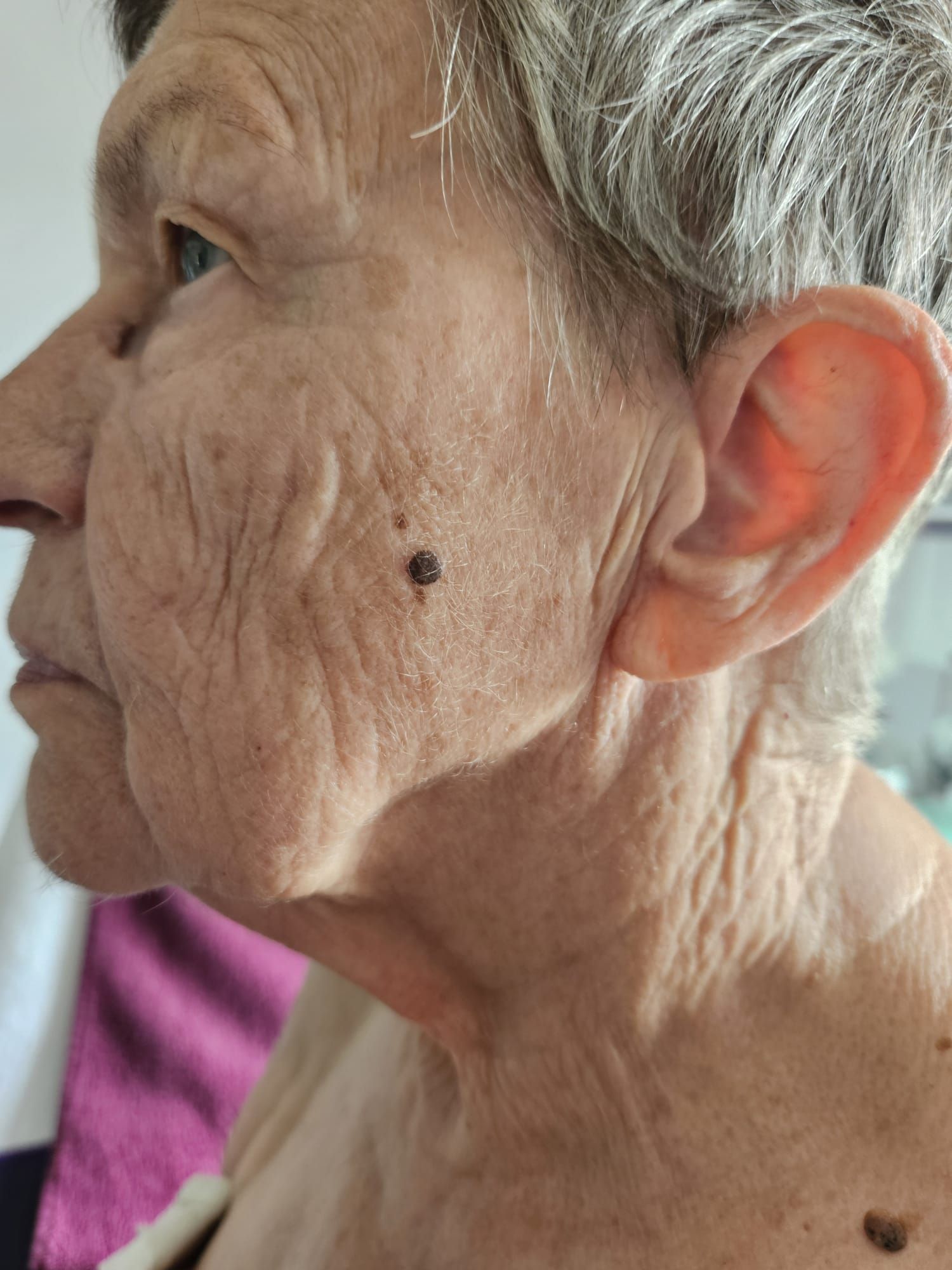 Eine Nahaufnahme des Gesichts einer Frau vor unscharfem Hintergrund.