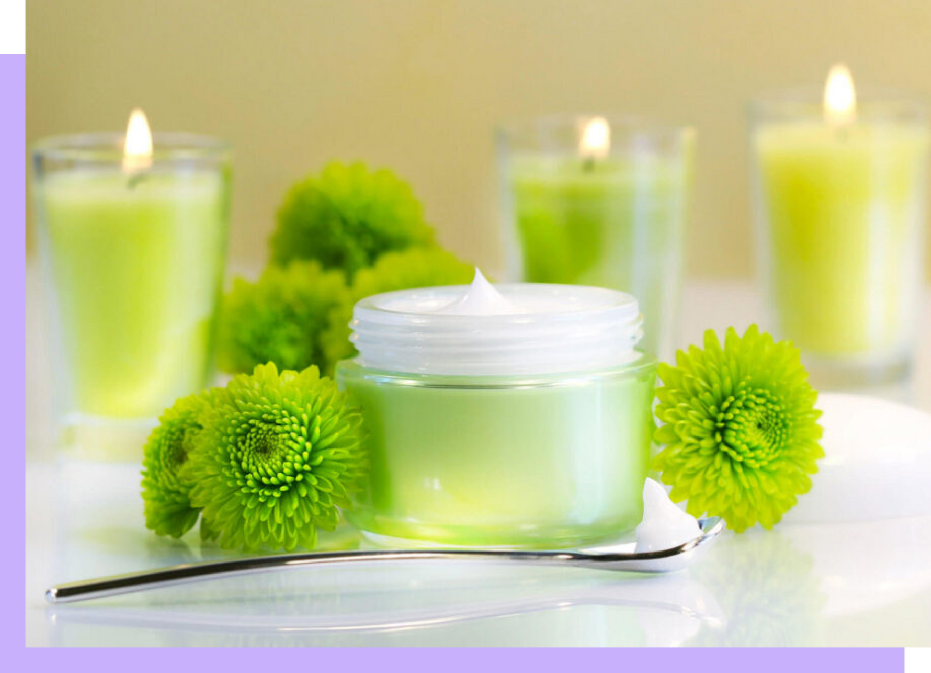 Ein Glas Sahne ist von grünen Blumen und Kerzen umgeben.