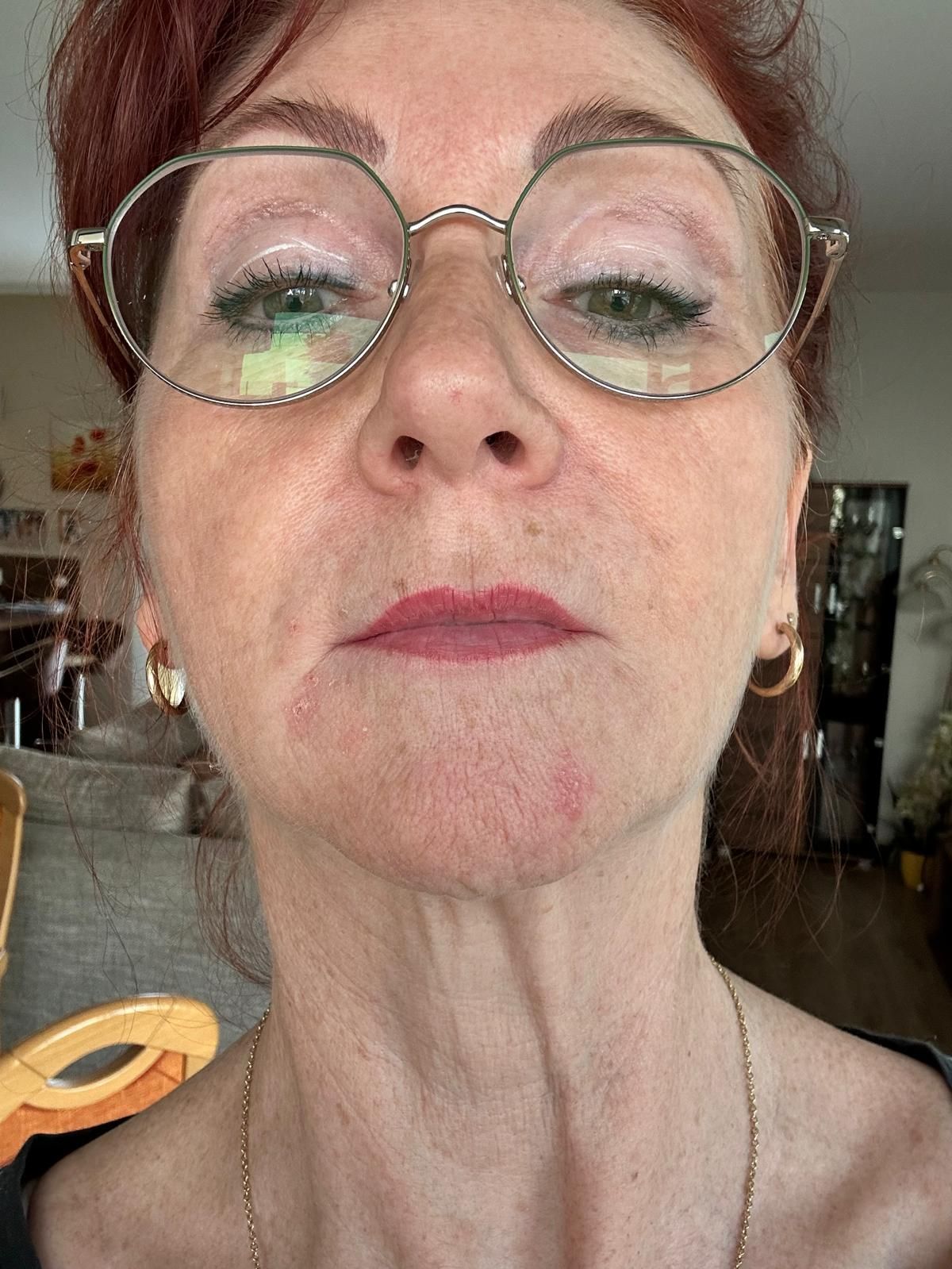 Eine Nahaufnahme des Gesichts einer Frau mit geschlossenen Augen und roten Lippen.