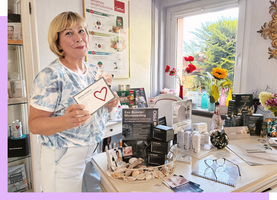 Eine Frau sitzt an einem Tisch und schreibt in ein Notizbuch.