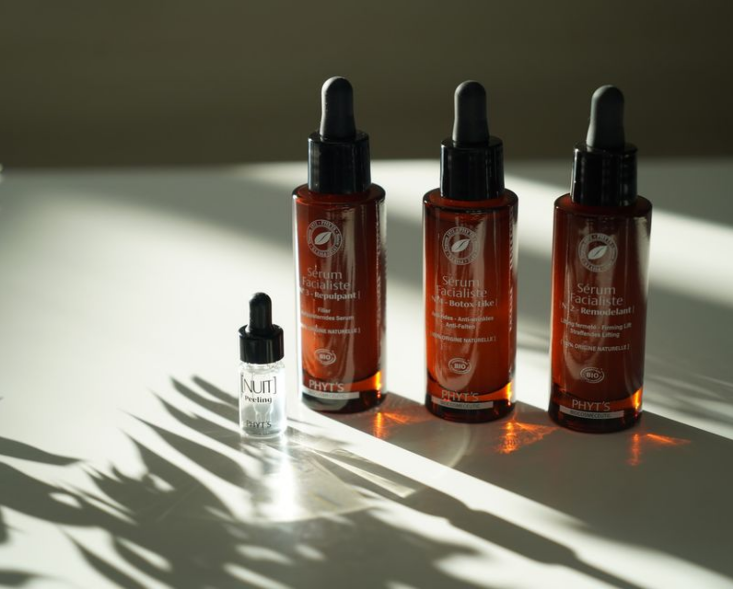 Drei Flaschen Kosmetika stehen auf einem Tisch