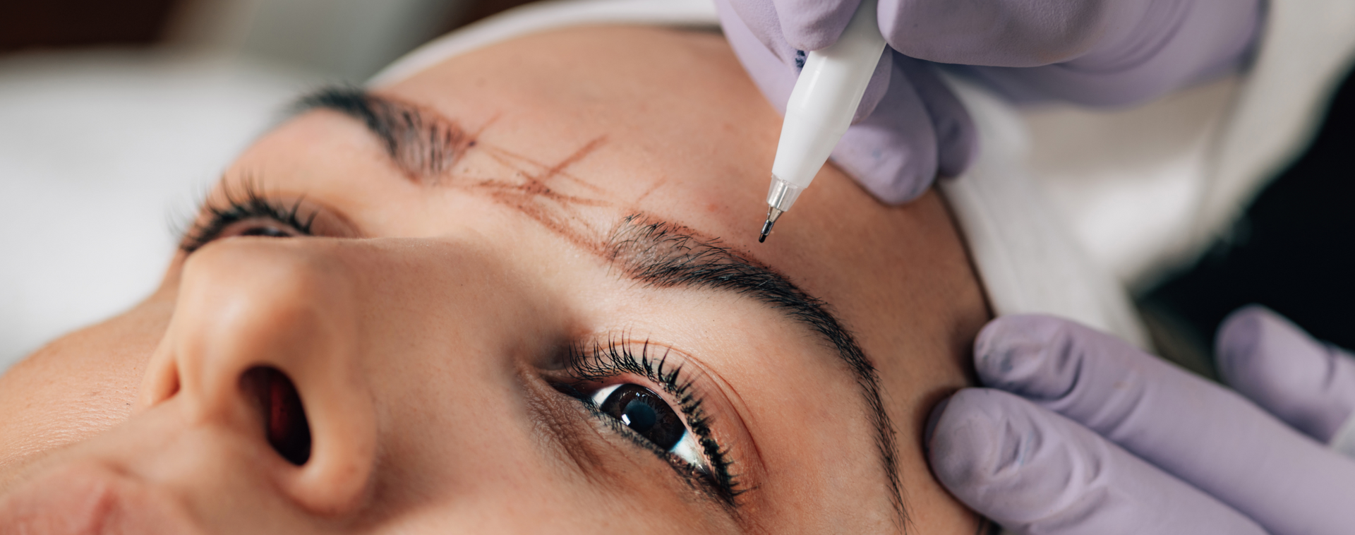 Eine Frau lässt sich Permanent Make-up auf die Augenbrauen machen.