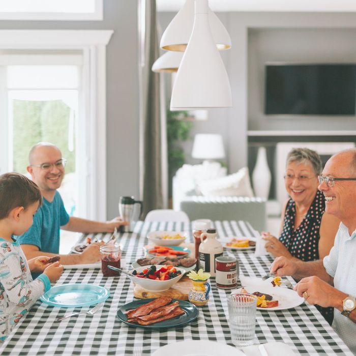 A family is sitting at a table eating food.